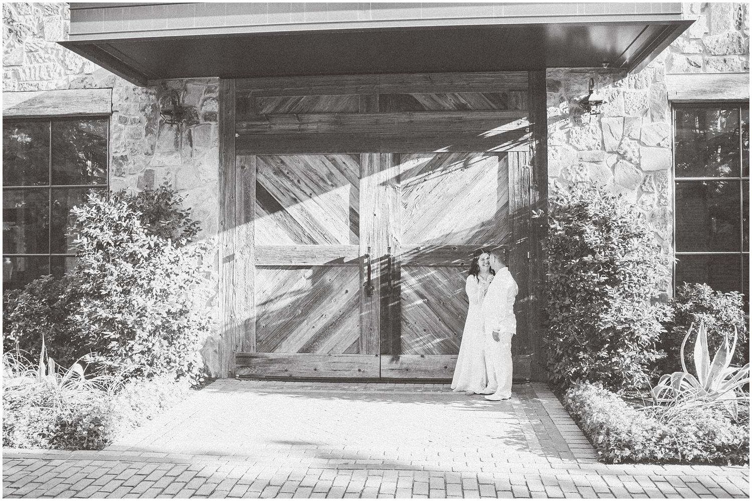 Black and white photos of a couple posing near a stone wall entrance.