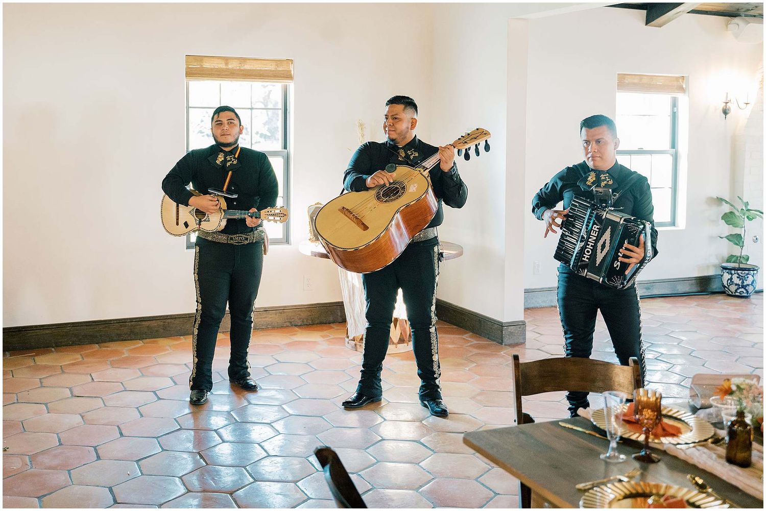 Musicians performing with guitars and instruments at an indoor wedding reception.