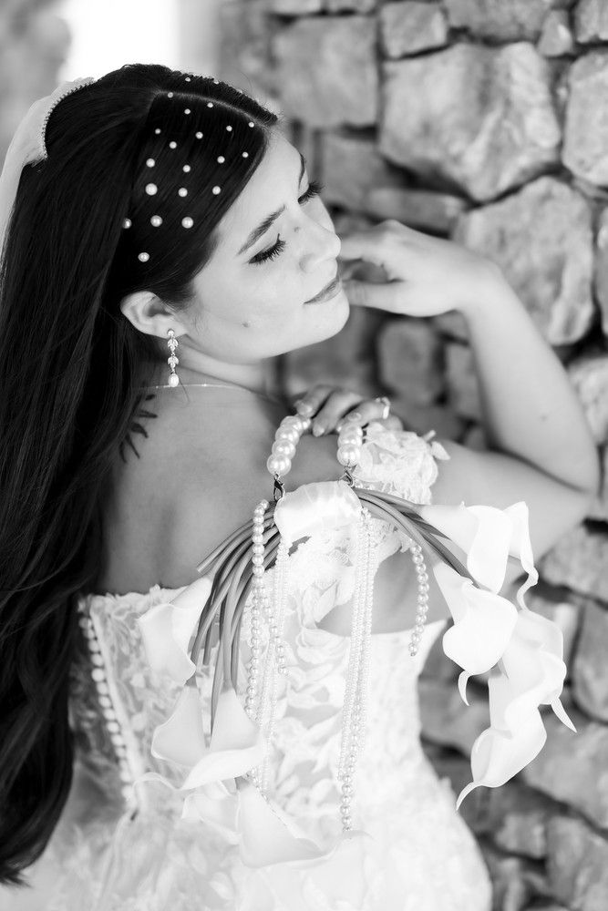 A series of black and white artistic bridal portraits showing elegant details of pearls and lace against a stone wall background.