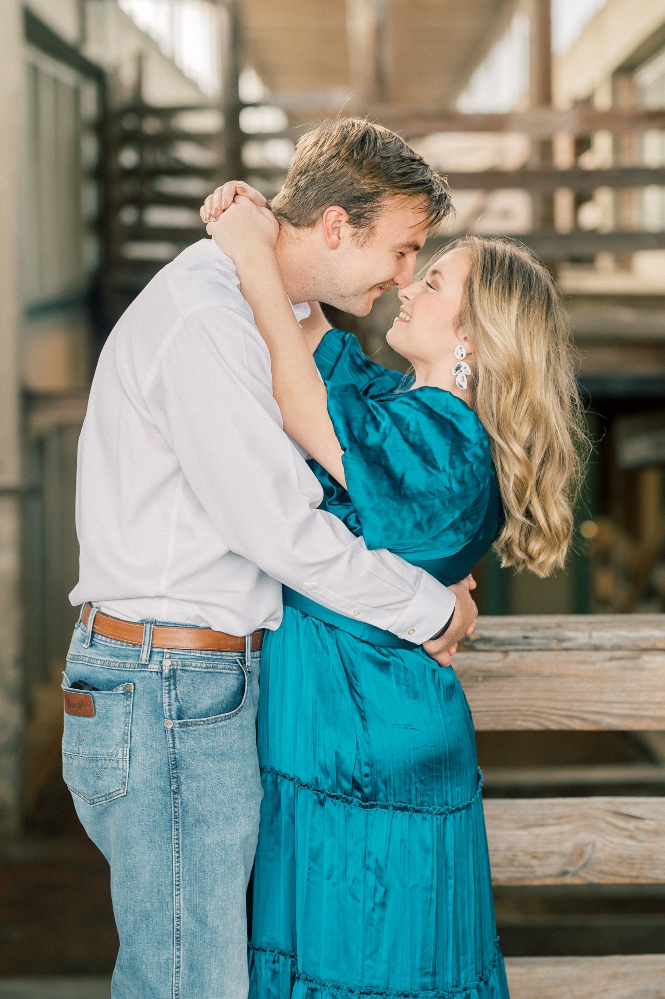 Sweet couple sharing intimate moments by wooden railings in an indoor venue.
