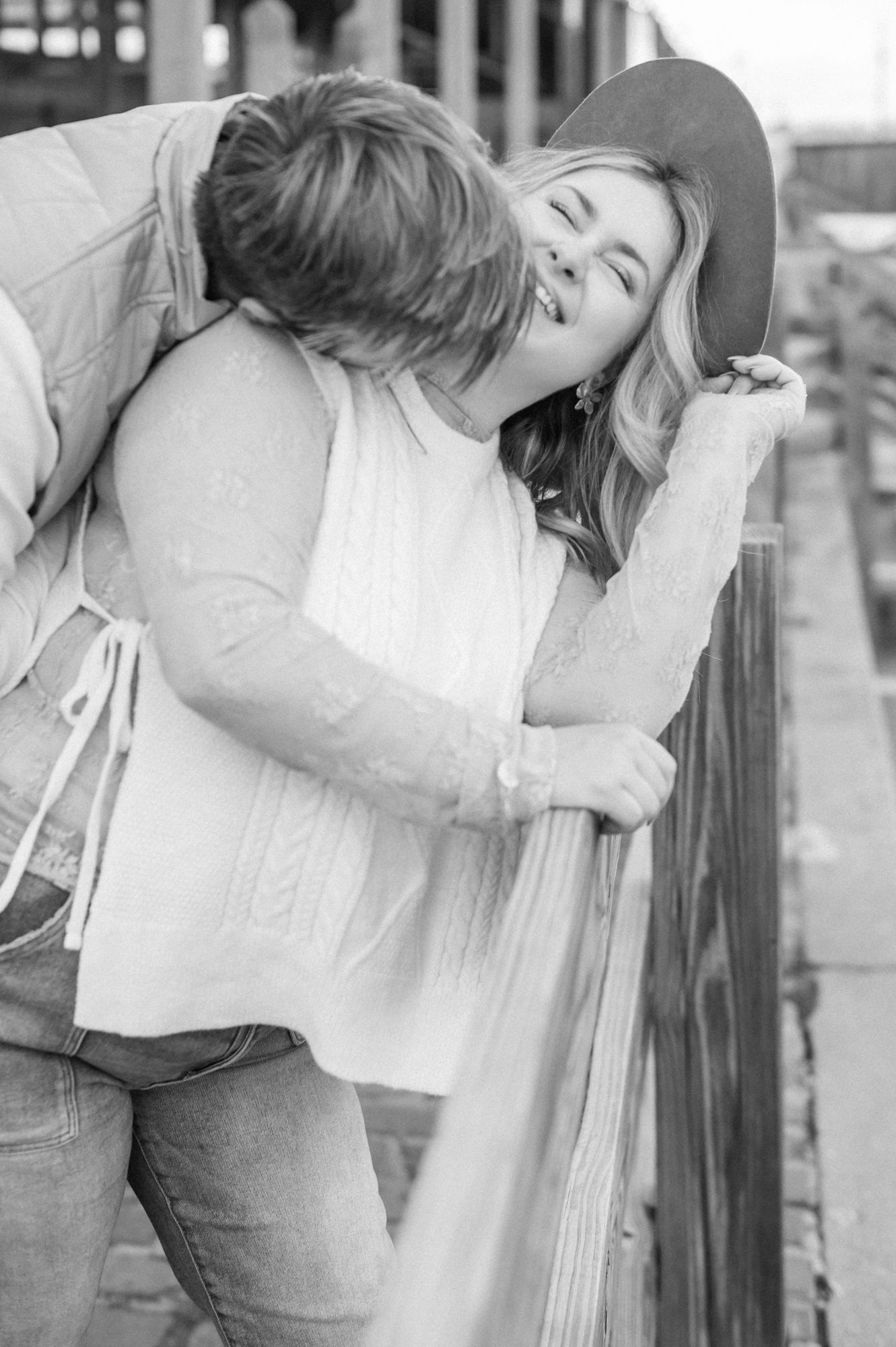 Black and white photo of couple sharing romantic moments on rustic steps.