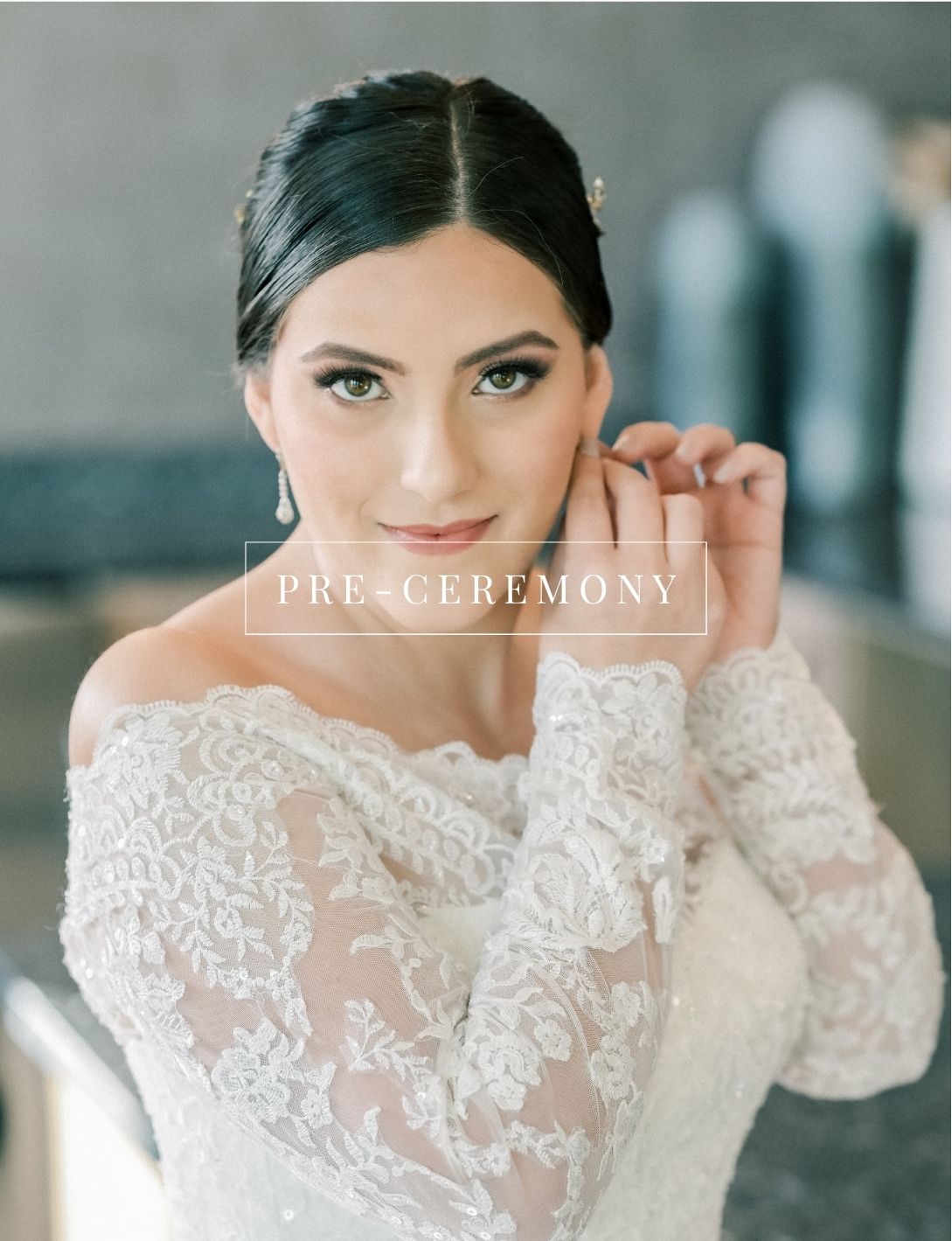 Elegant bride in off-shoulder lace wedding gown with bridal makeup and updo hairstyle during pre-ceremony preparations.
