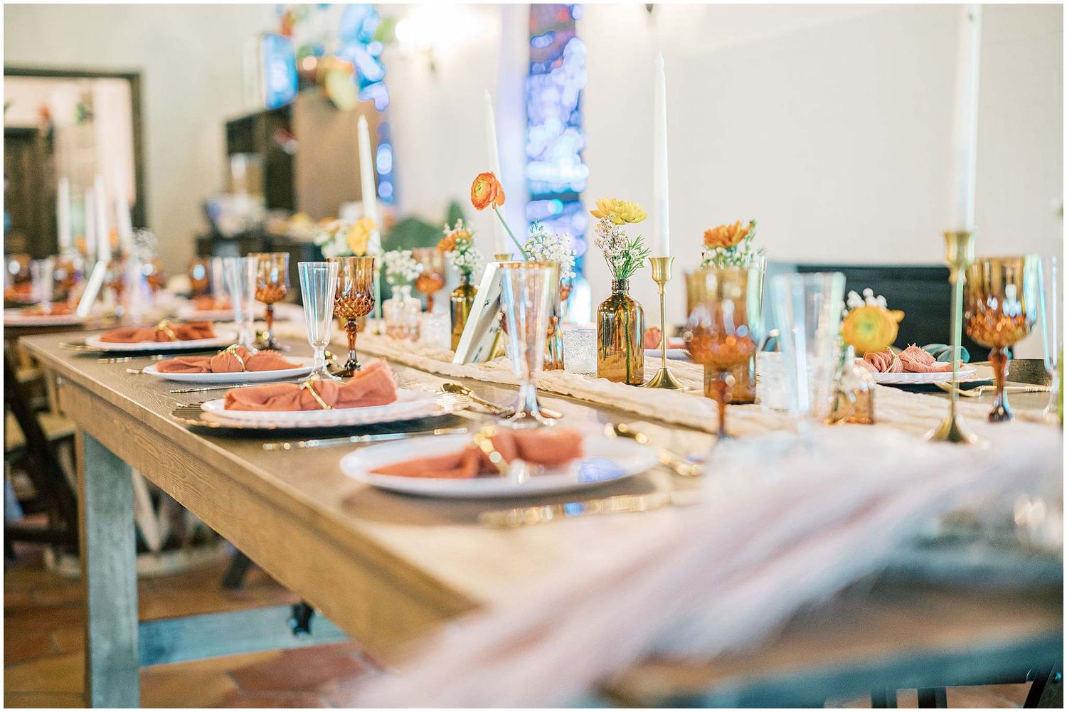 Wedding reception table decorated with floral centerpieces and golden accents.
