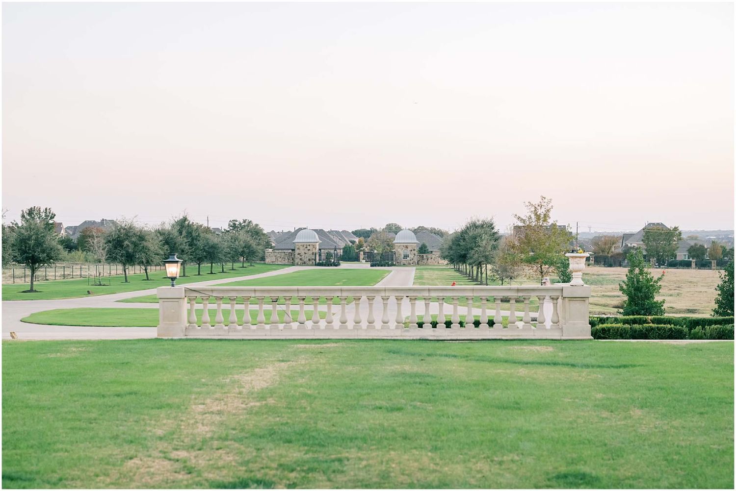 Panoramic view of a grand estate venue with manicured lawns and classical architecture.