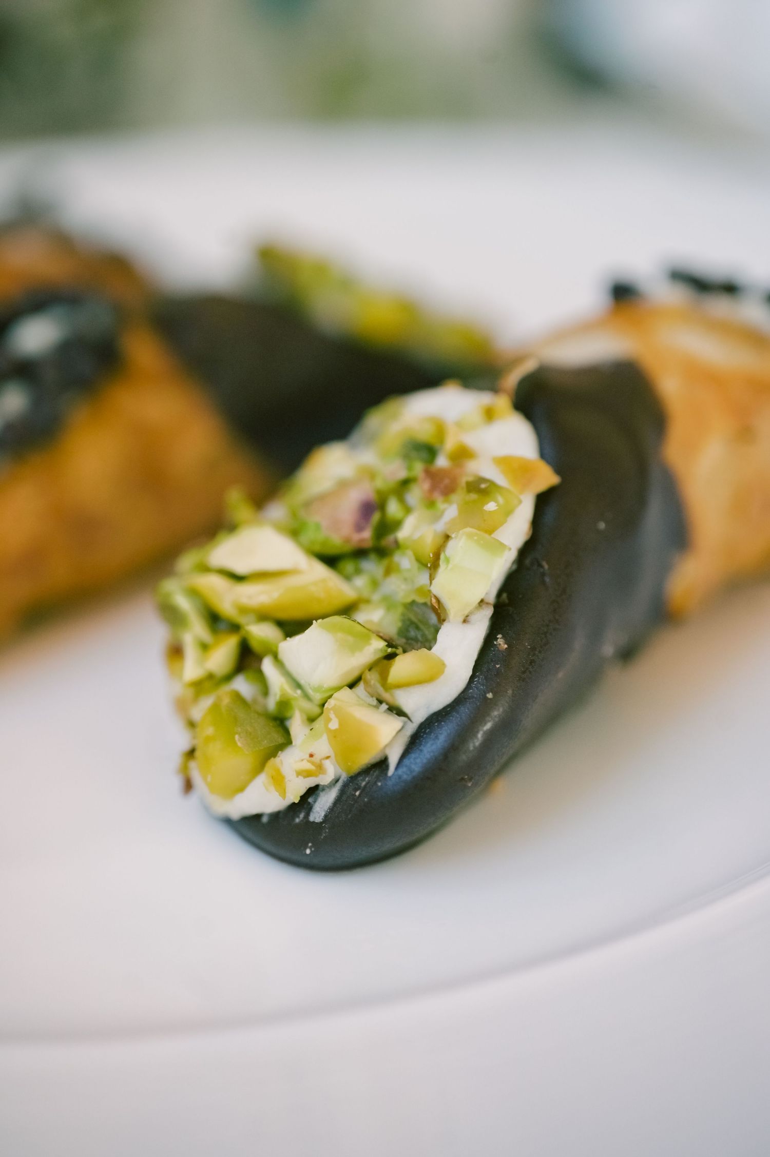 Gourmet appetizers served on black spoons with colorful garnishes.