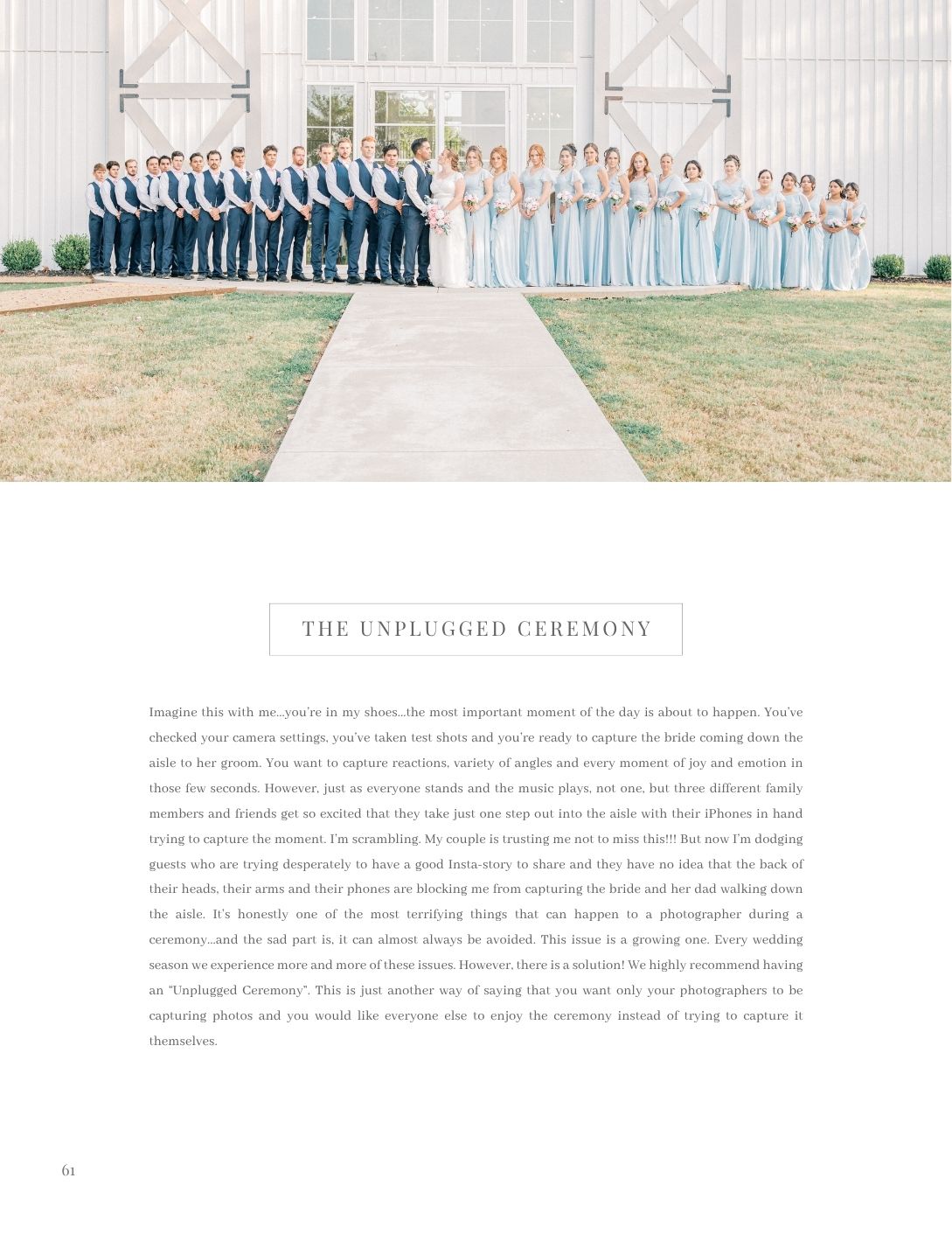 Large wedding party poses outdoors in coordinated blue and white attire beside a white barn venue.