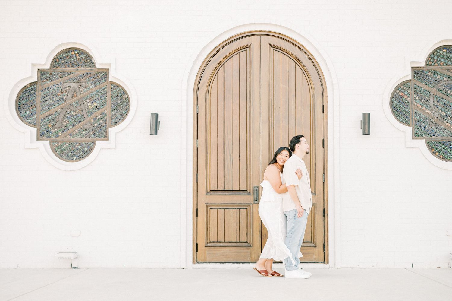 A series of four photos showing a couple in traditional wedding attire posing against white walls and wooden doors.