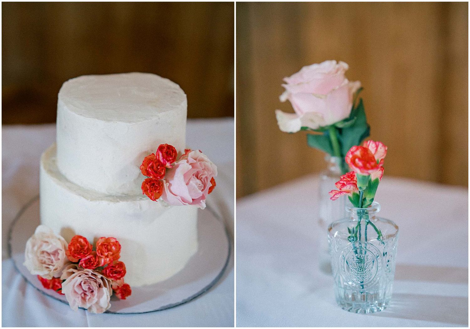 White wedding cake decorated with delicate coral and pink sugar flowers on display at rustic reception.
