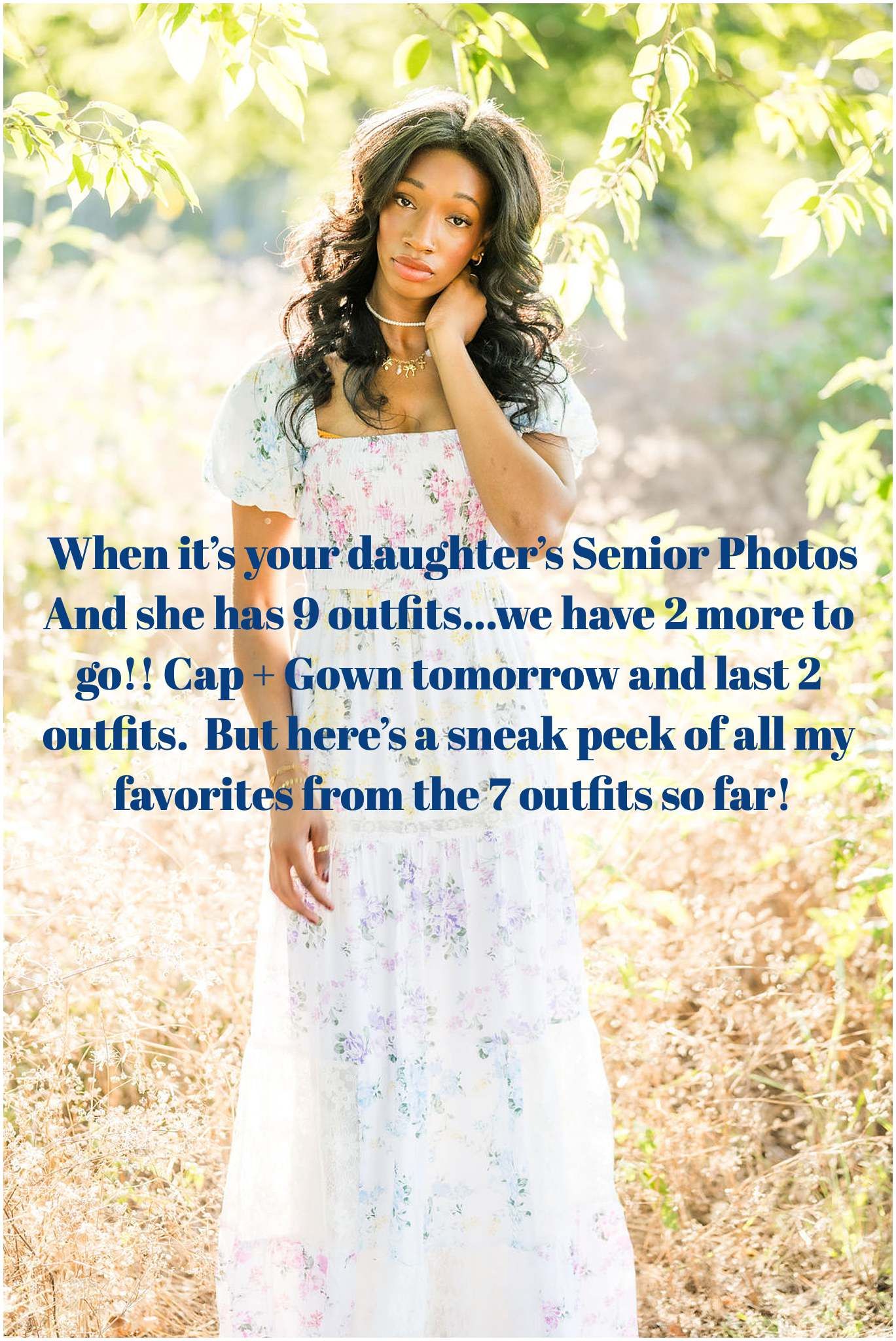 A young woman in a white floral dress poses outdoors for senior photos among green foliage and natural light.