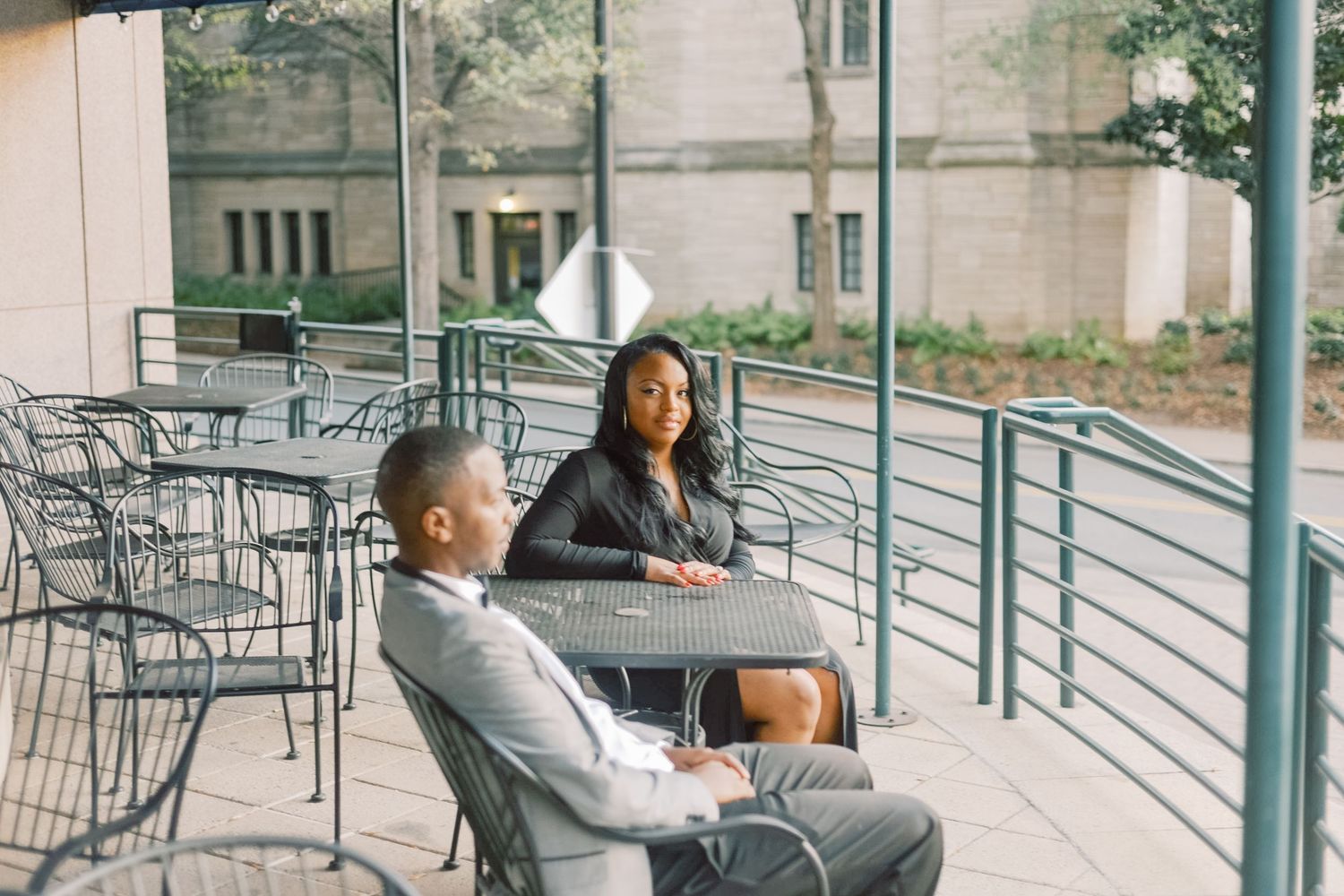 Couple sharing a quiet moment at an outdoor patio table in a urban setting.