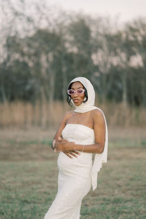Playful maternity shoot featuring retro sunglasses and white dress in outdoor setting.