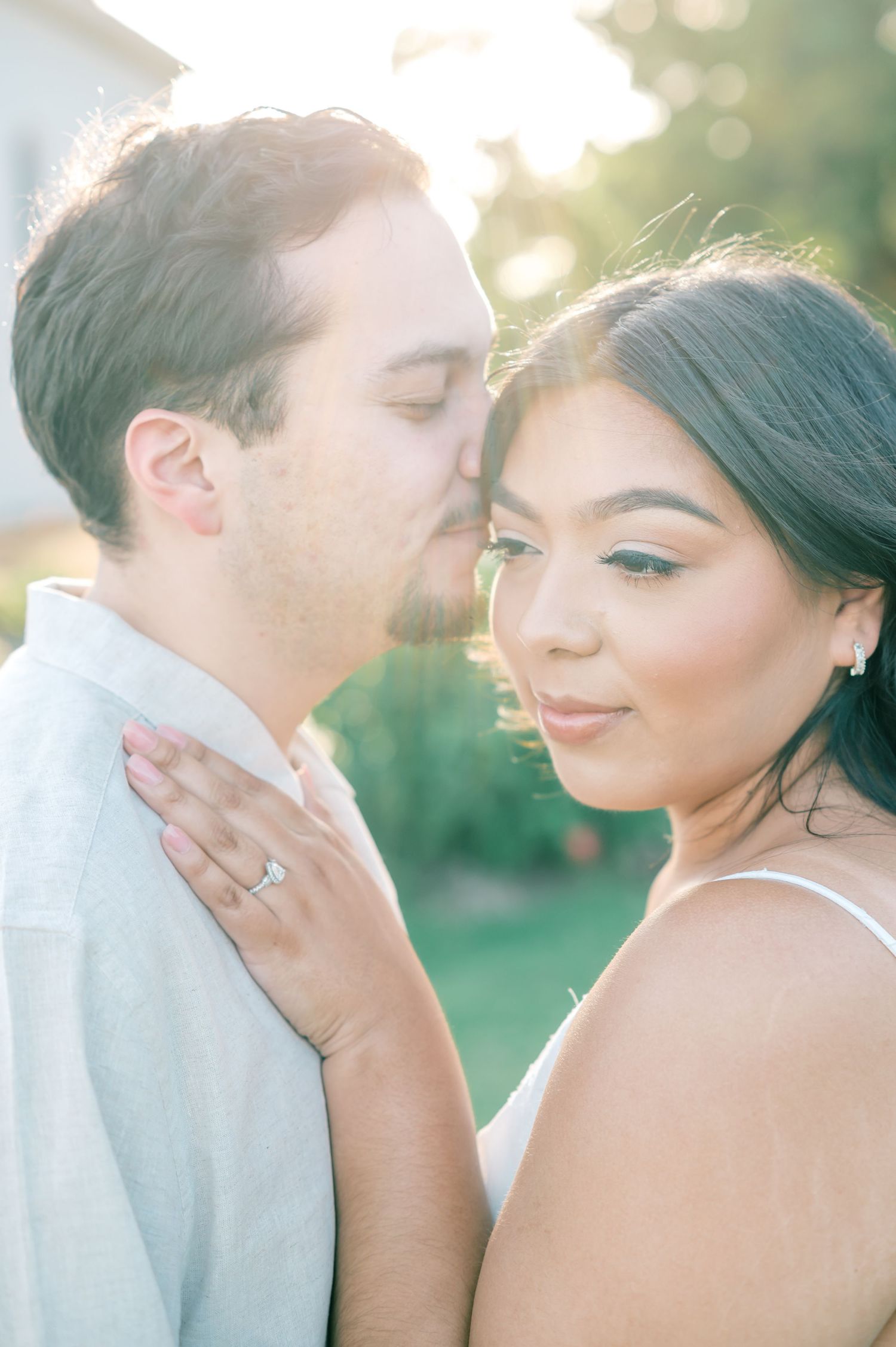 A romantic couple shares intimate moments in a sun-drenched outdoor setting with soft bokeh lighting effects.