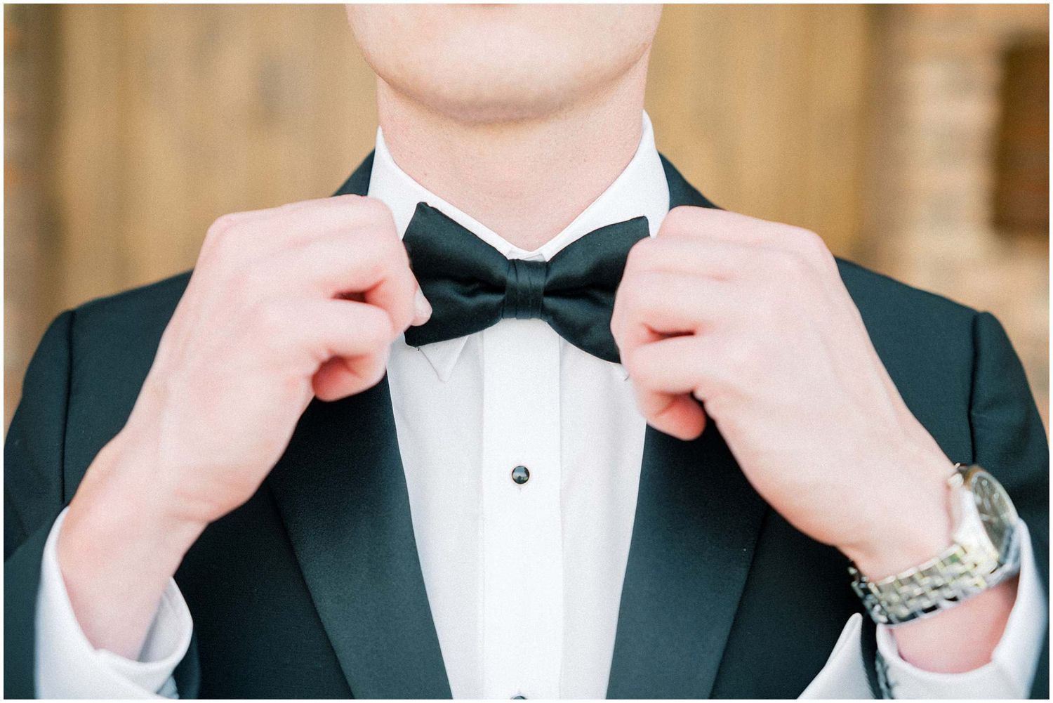 Detail shots of adjusting black bow tie and formal tuxedo.