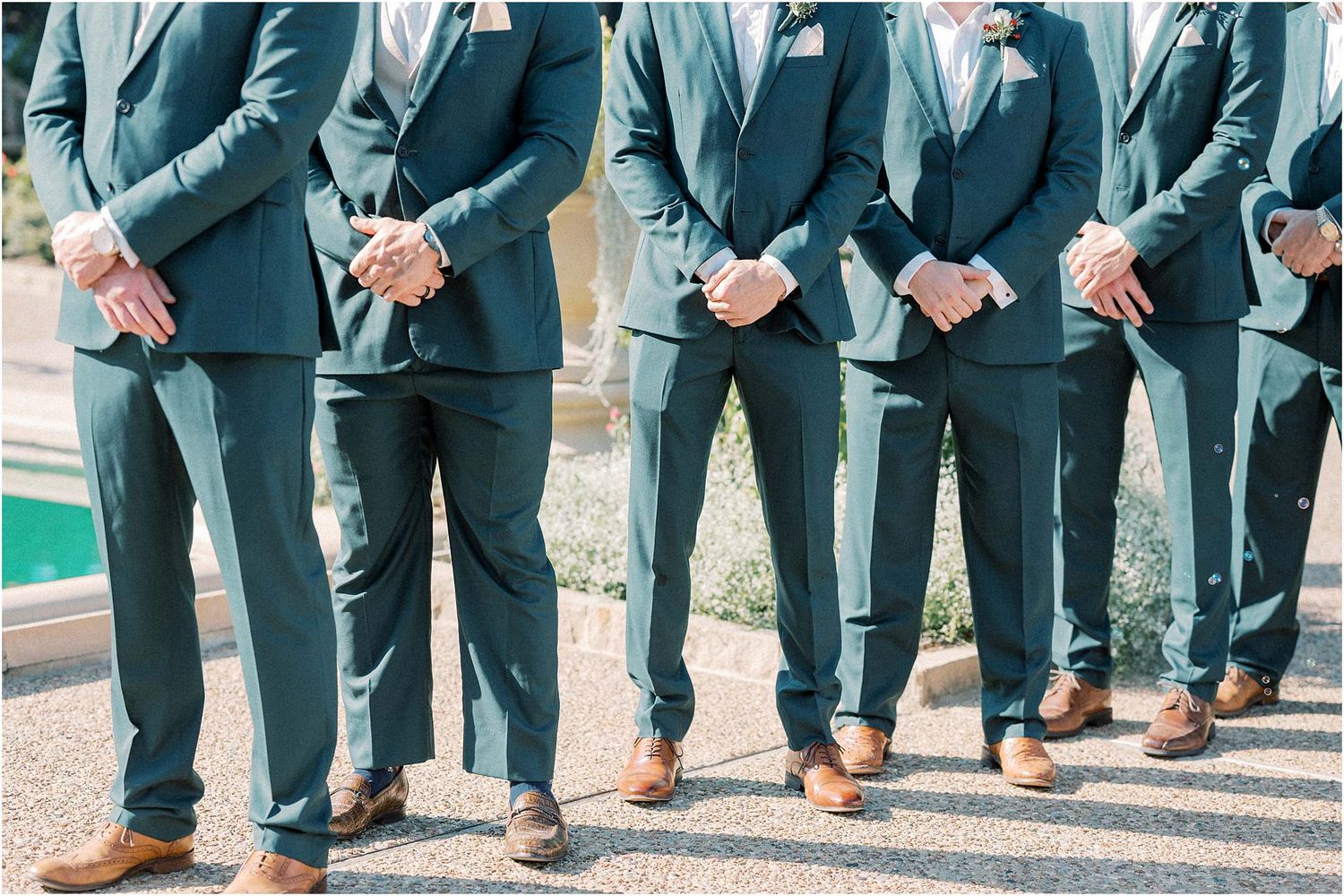 Groomsmen in matching blue suits and brown shoes lined up for wedding photo.