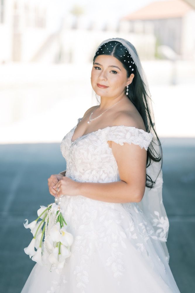 Elegant bridal portraits featuring a white lace wedding gown and pearl headpiece with delicate lily bouquet.