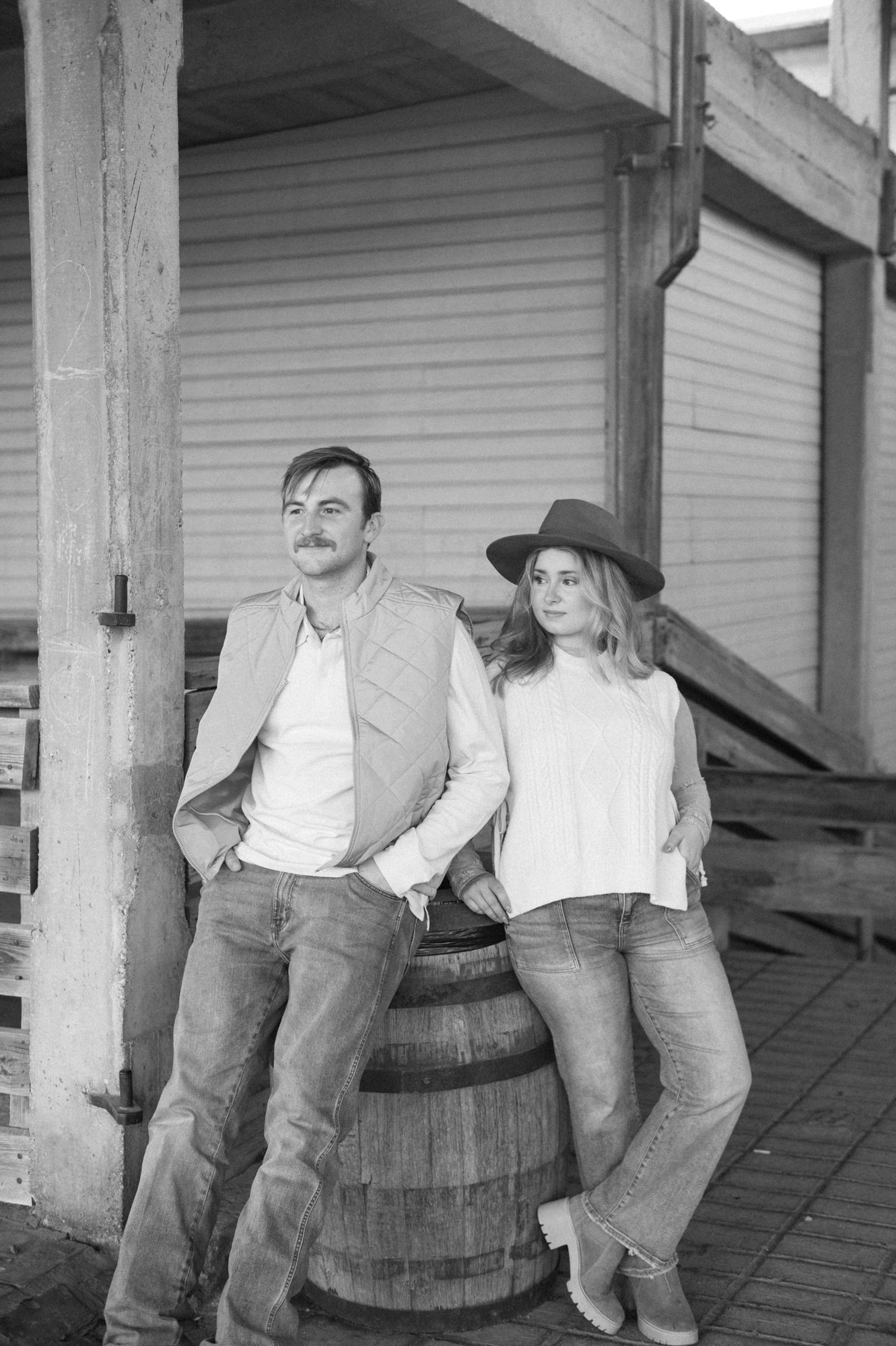 A sequence of black and white photos showing a person sitting on a barrel while another person leans against it.