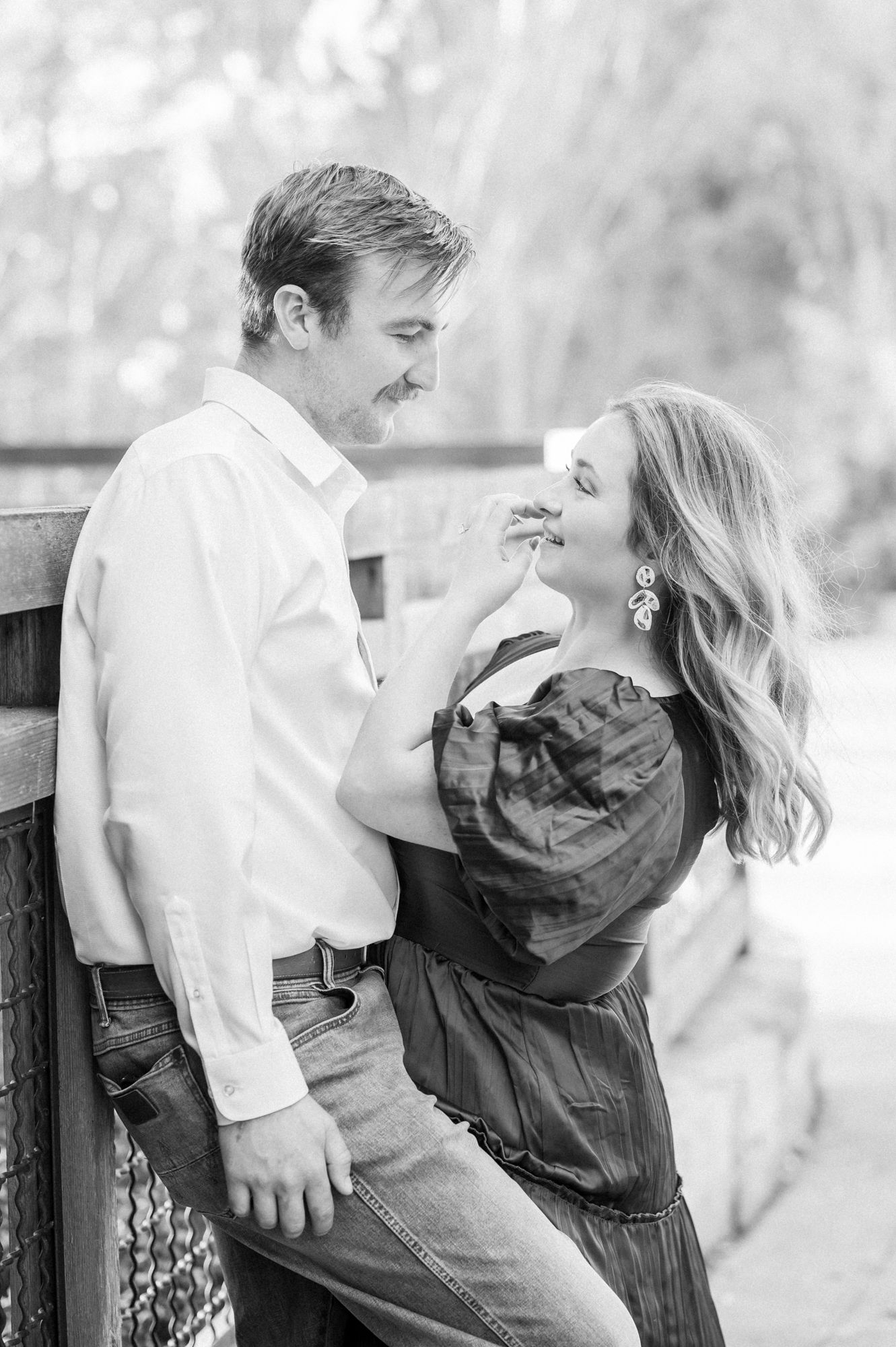 A romantic black and white photo series showing a couple embracing on a park bench in an intimate moment.