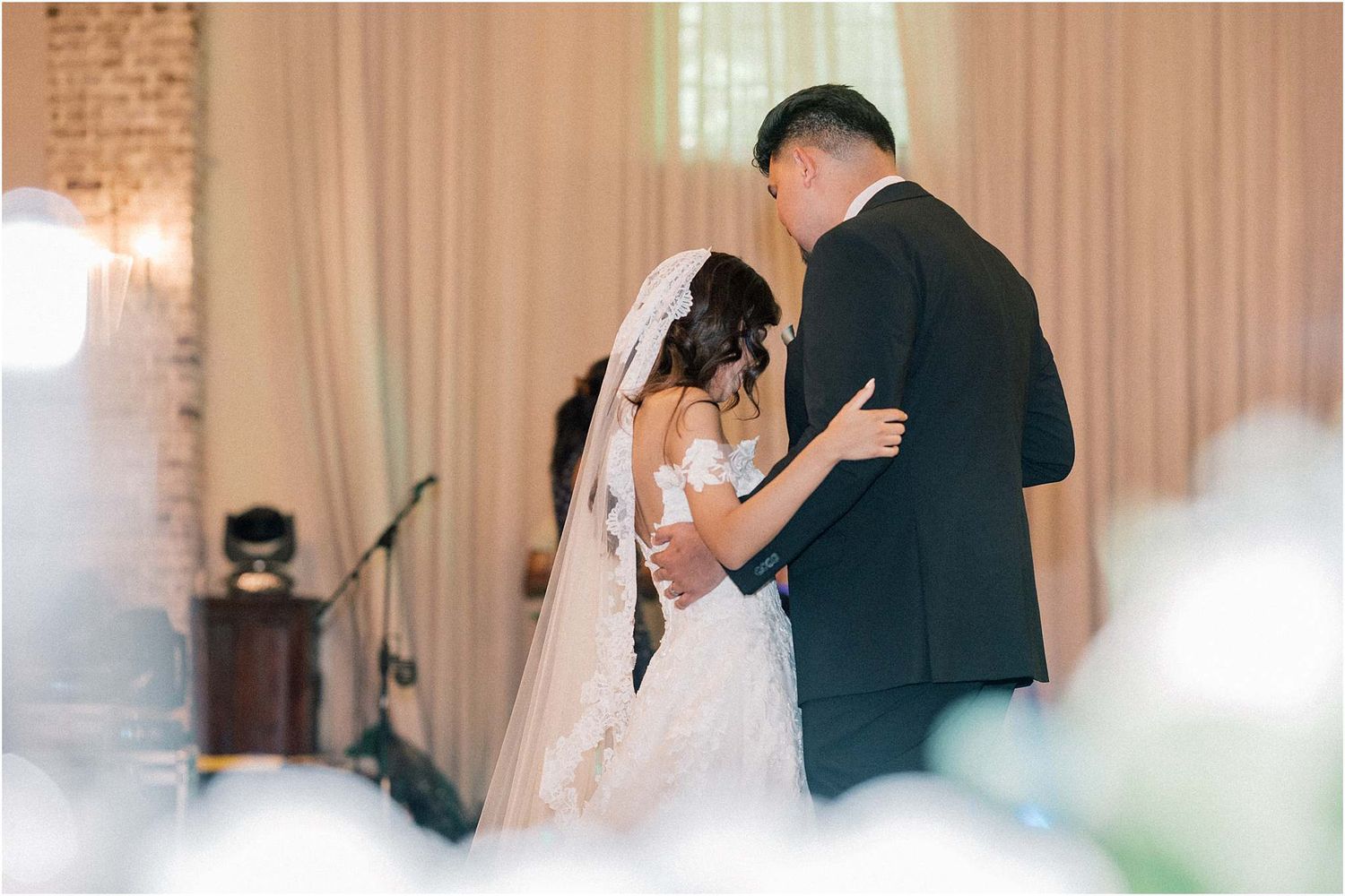 Intimate first dance moment between newlyweds in elegant reception venue.
