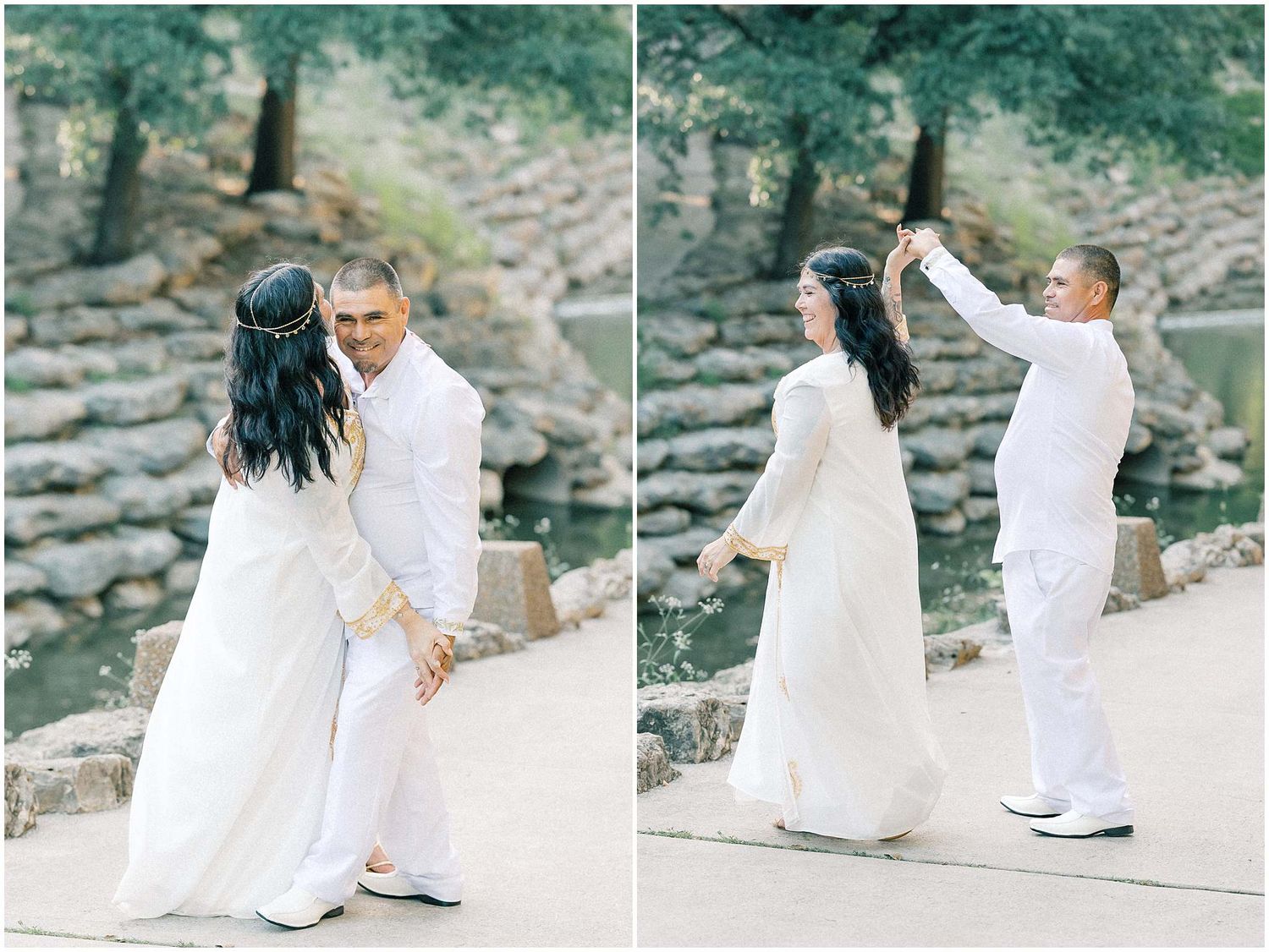 A couple in white outfits poses together on stone steps in a natural setting.