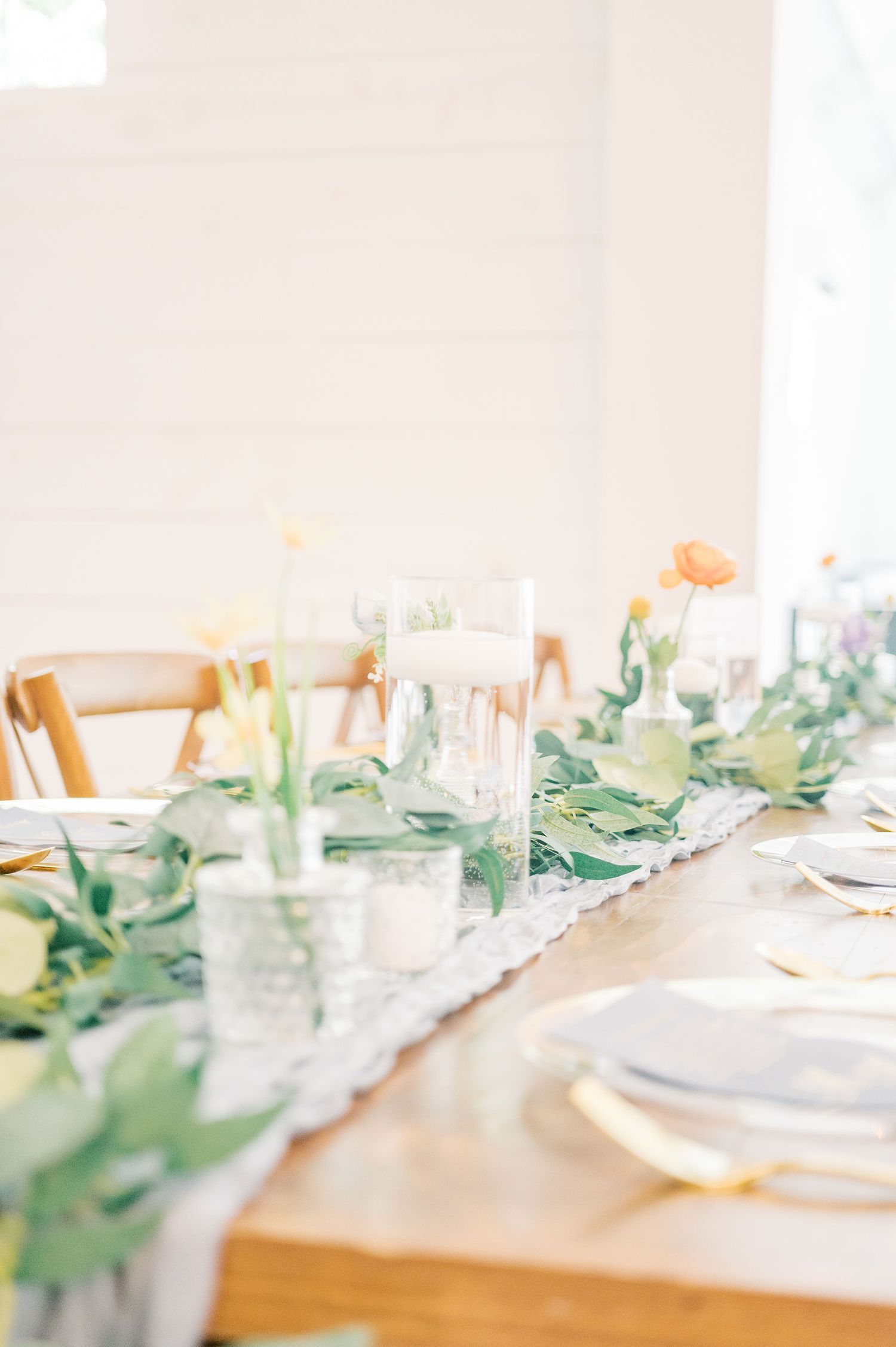Elegant wedding reception table setting with greenery and soft pastel decor.