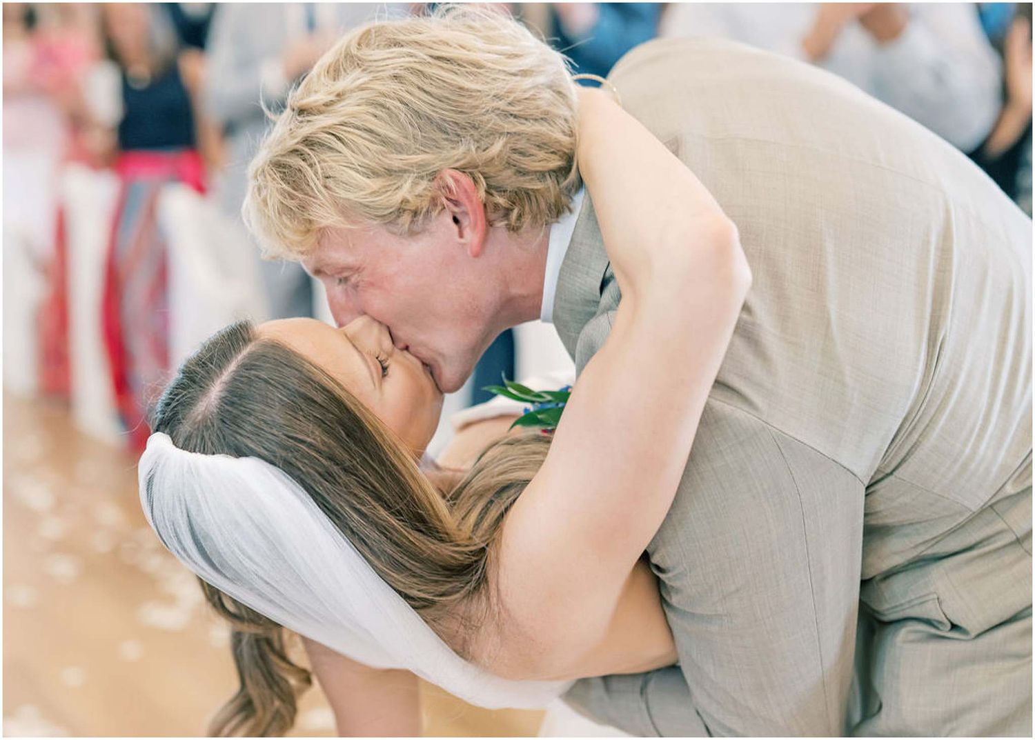 Bride and groom share a romantic dip kiss on their wedding dance floor.