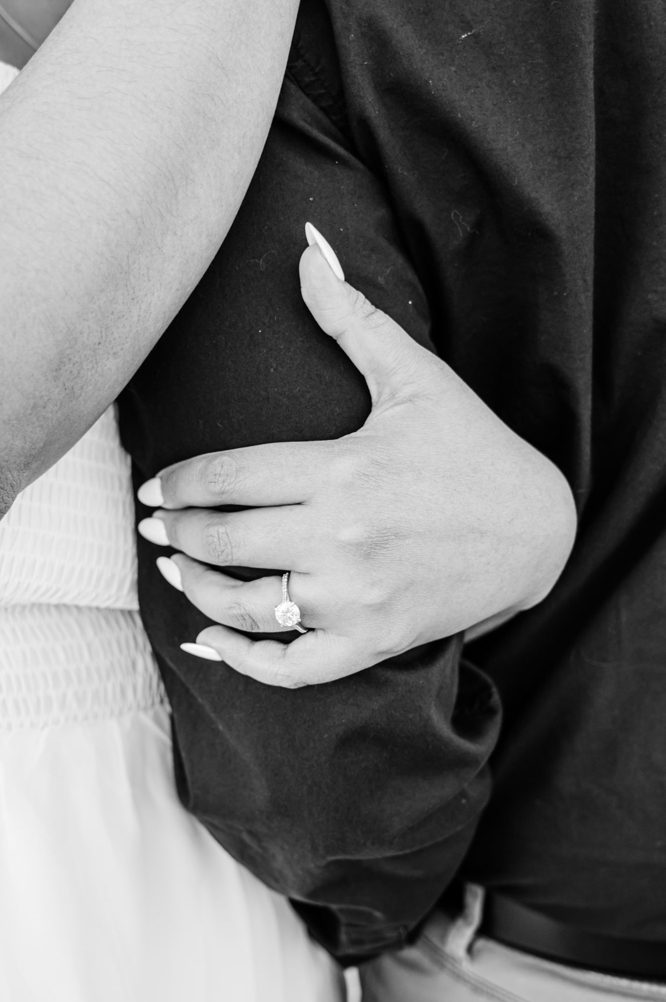 Black and white close-up shots showing tender embraces between a couple wearing contrasting black and white outfits.