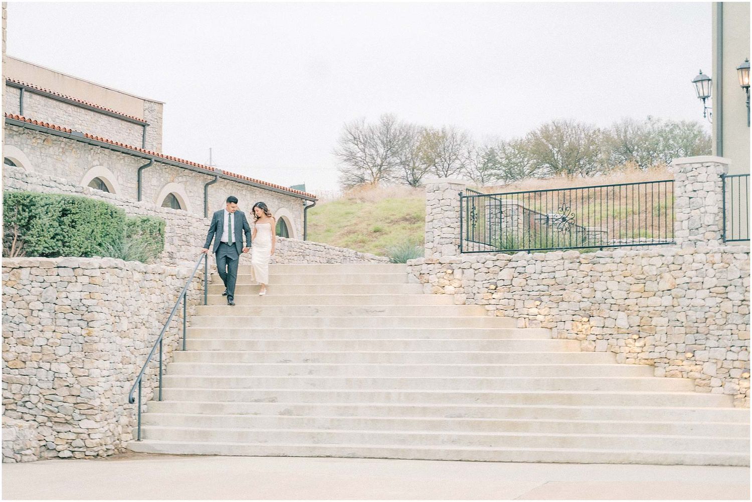 Stone architecture and archways frame an elegant outdoor photoshoot setting with natural lighting.