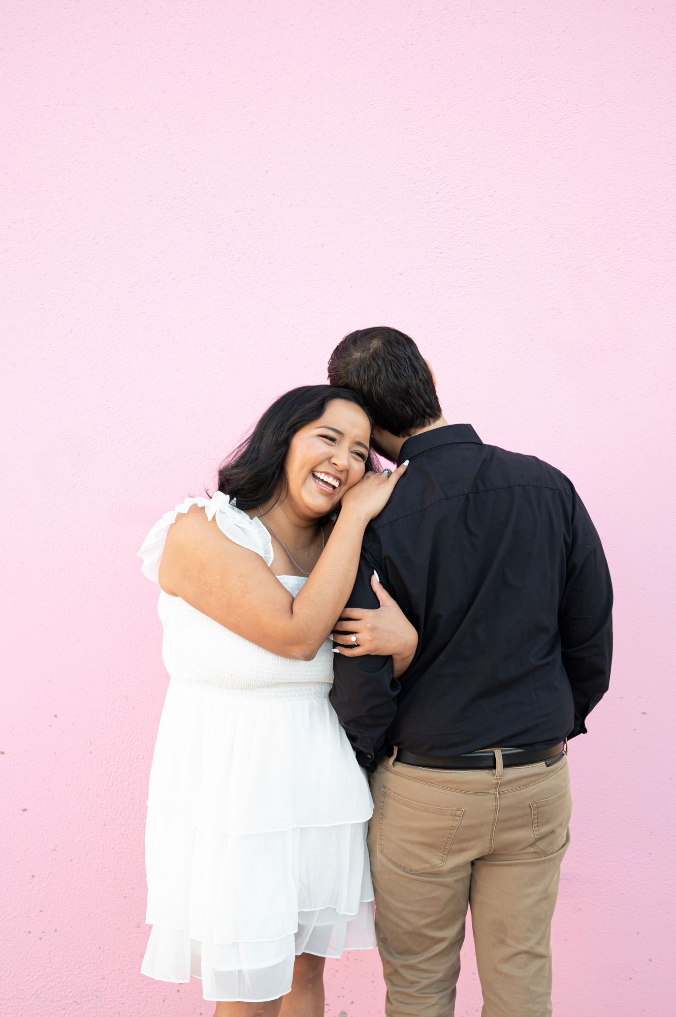 A playful couple shares intimate moments against a pink backdrop in a photo sequence.