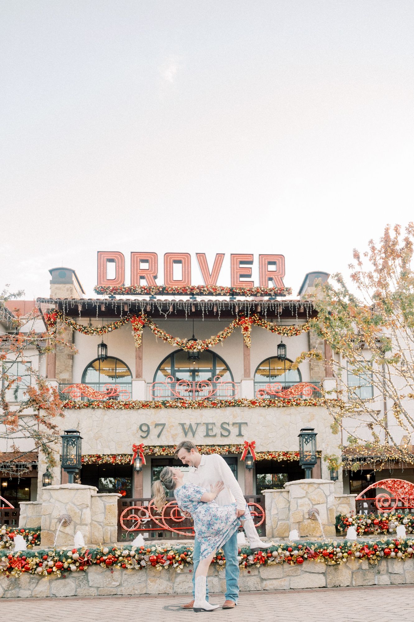 A romantic scene in front of the decorated Drover restaurant at 97 West with holiday lights and floral arrangements.