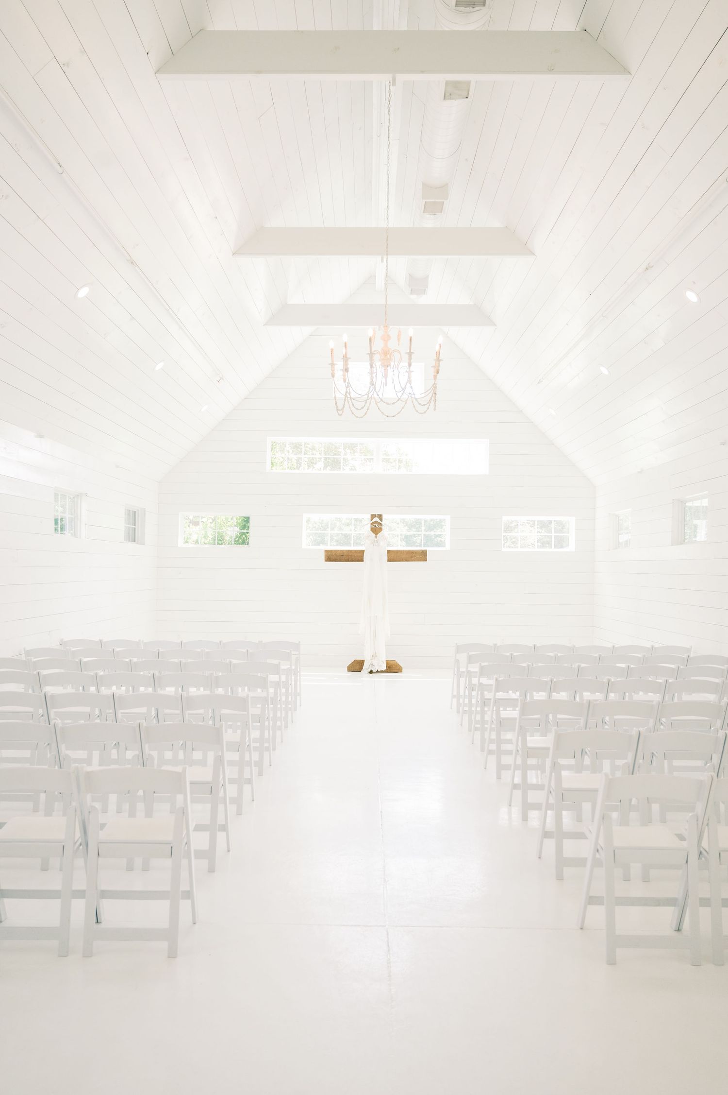 White chapel interior with rows of chairs set up for wedding ceremony.