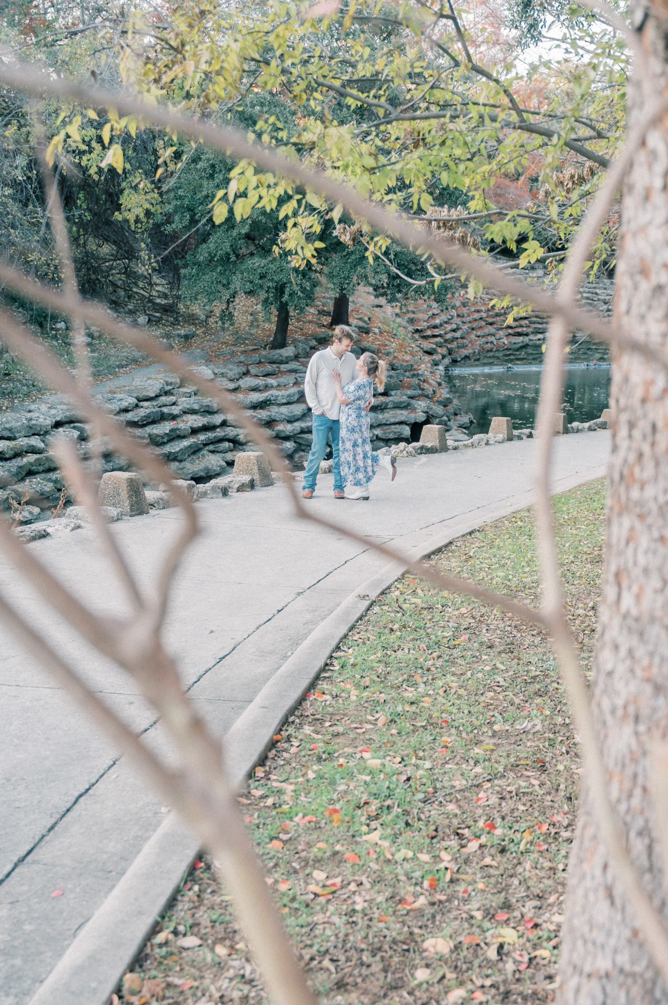 A series of stone steps wind through an autumn garden with fallen leaves and trees creating a peaceful pathway.