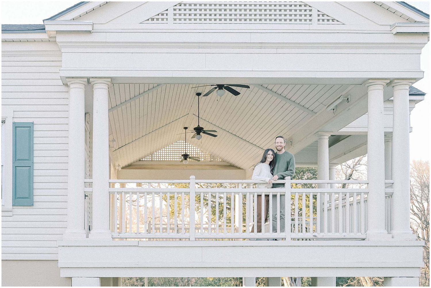 A white southern-style porch with decorative lattice and ceiling fans creates an elegant outdoor living space.