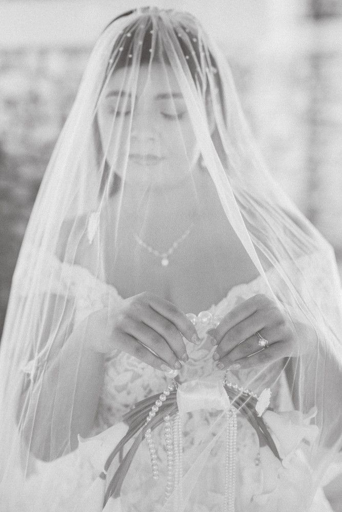 Ethereal bridal portraits with delicate veil details captured in soft black and white.