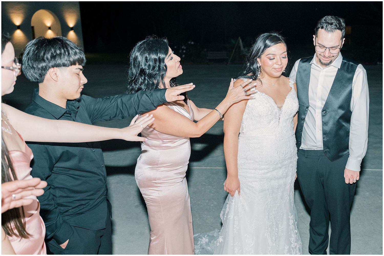 Wedding guests dance together at an evening reception in elegant formal attire.
