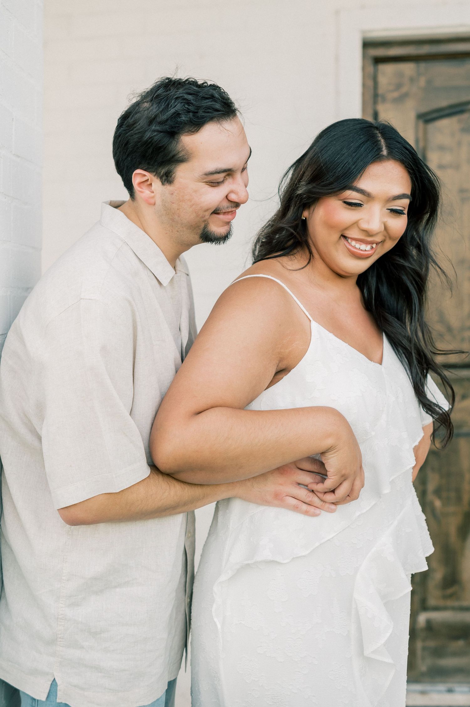 A romantic couple in white outfits share playful and intimate moments together in a series of candid photos.