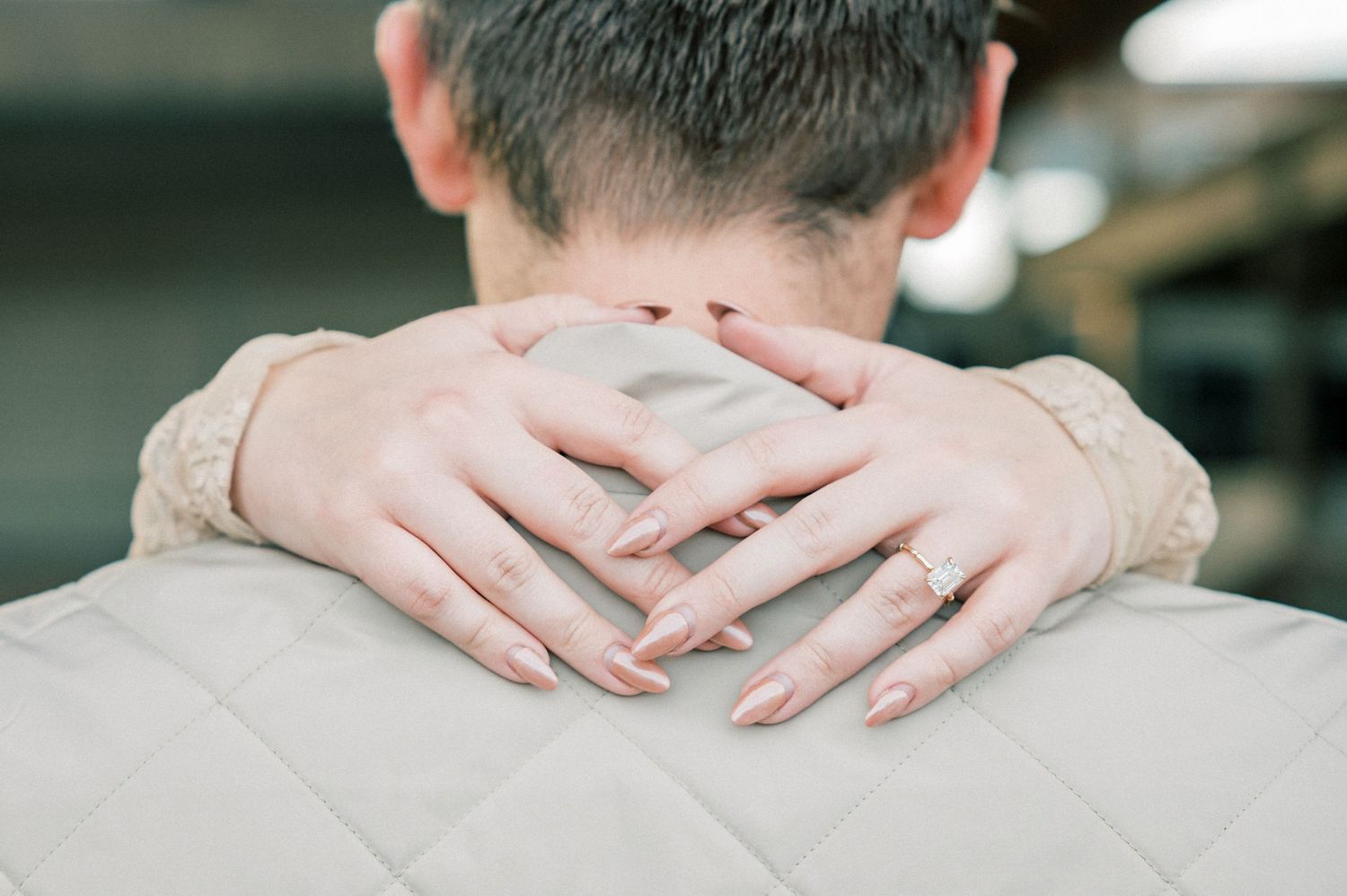 Close-up shot of hands resting gently on shoulders in a tender moment.