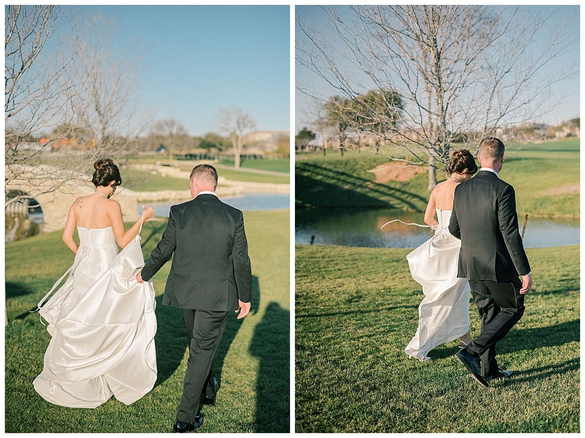 Wedding couple walks along grassy hill overlooking scenic pond at sunset.