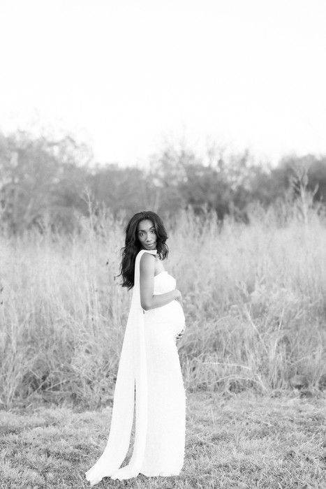 Artistic black and white portrait series of a person in a white dress posing gracefully in a sunlit meadow.