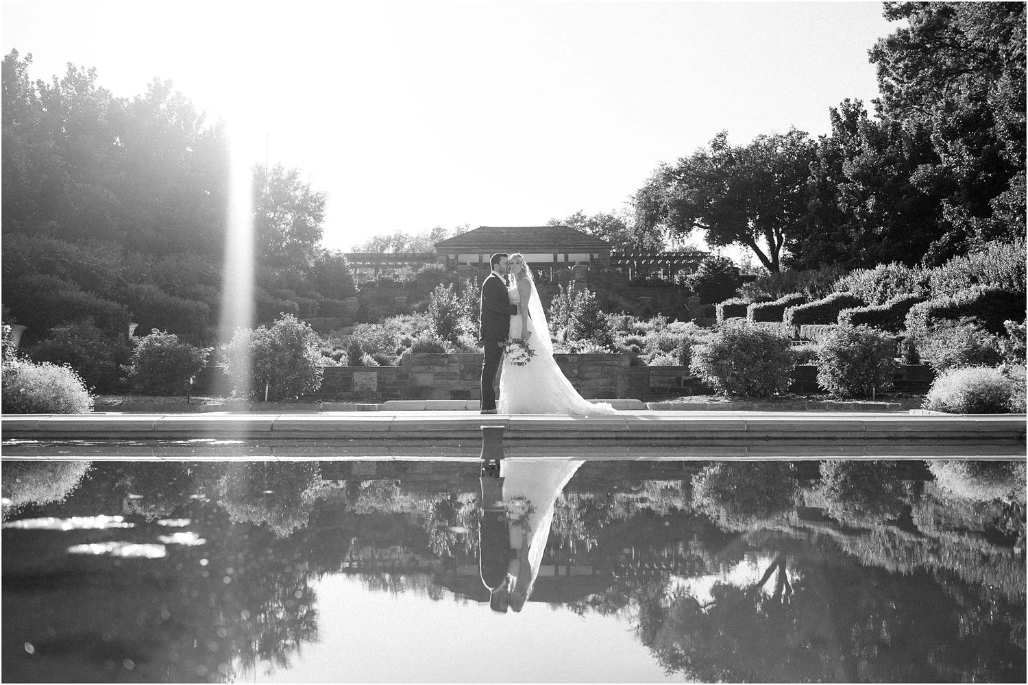 Black and white panoramic view of elegant outdoor wedding venue at sunset.