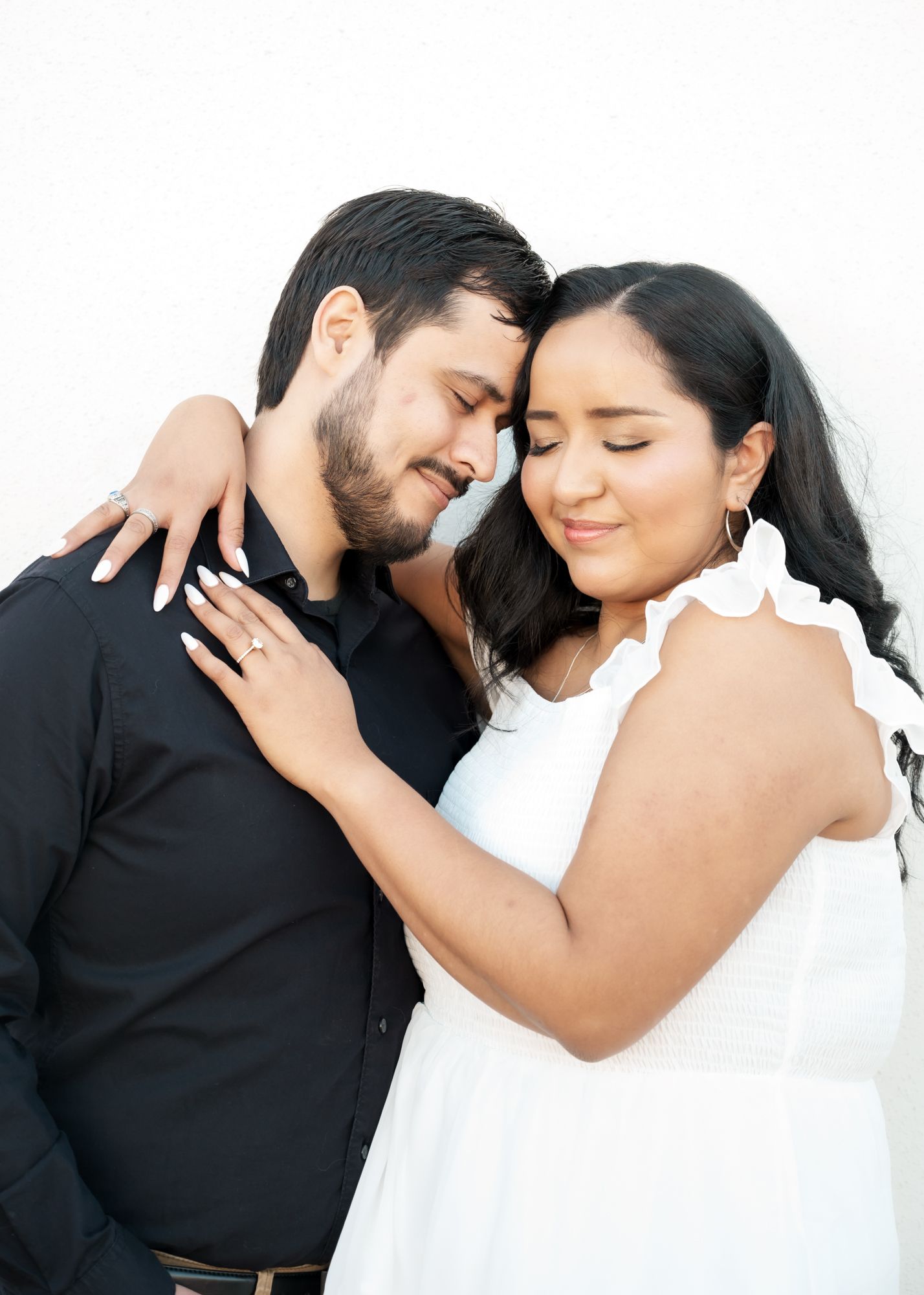 An intimate moment shared between a couple in black and white attire.