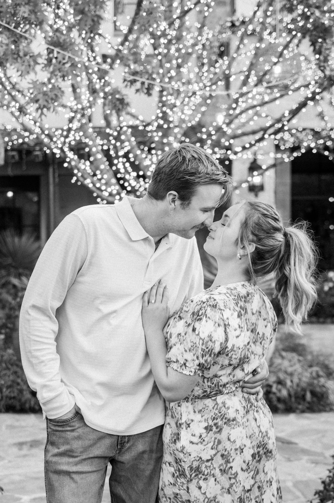 Intimate black and white portrait sequence under twinkling tree lights.