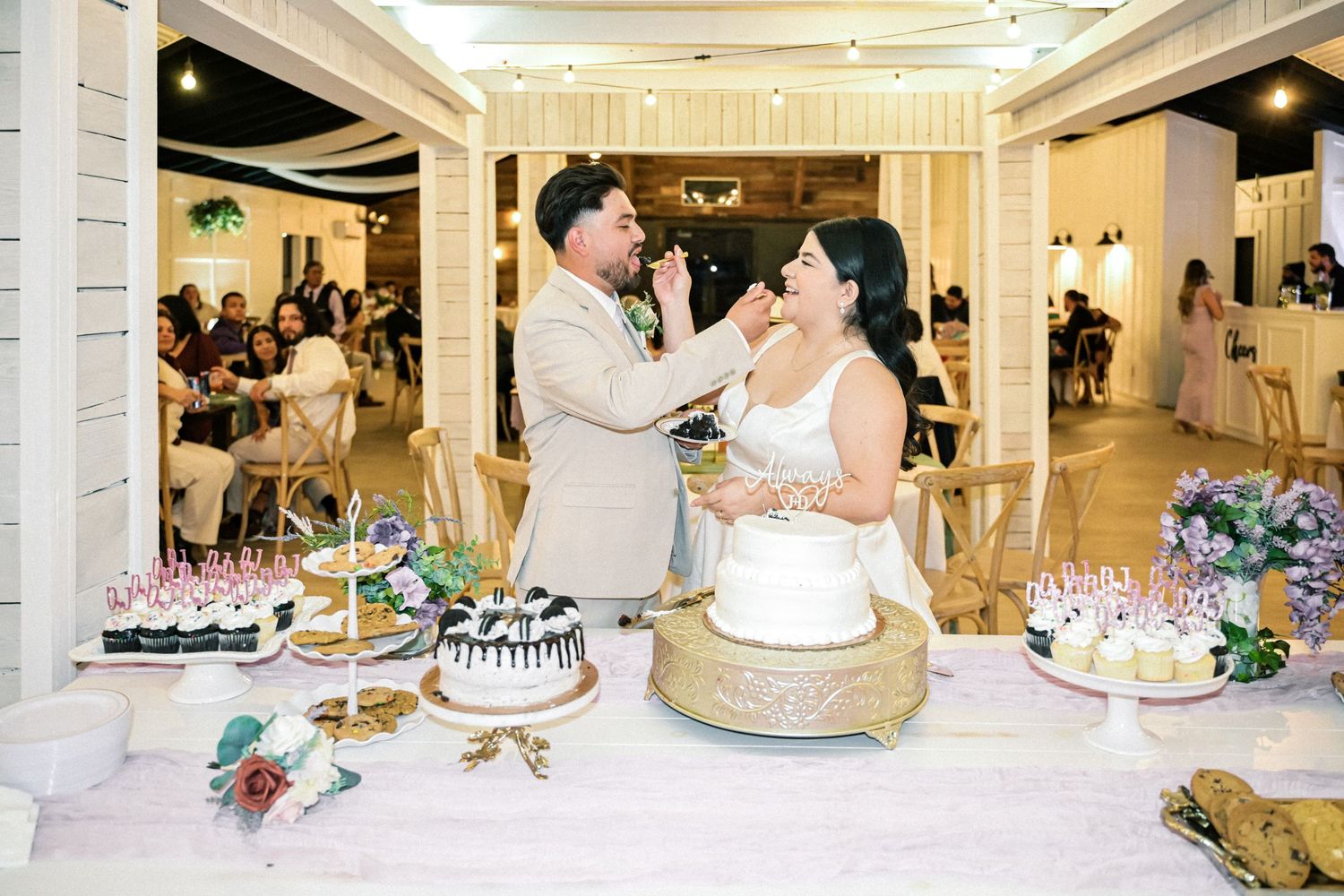 Happy couple sharing a moment while cutting their wedding cake at reception.