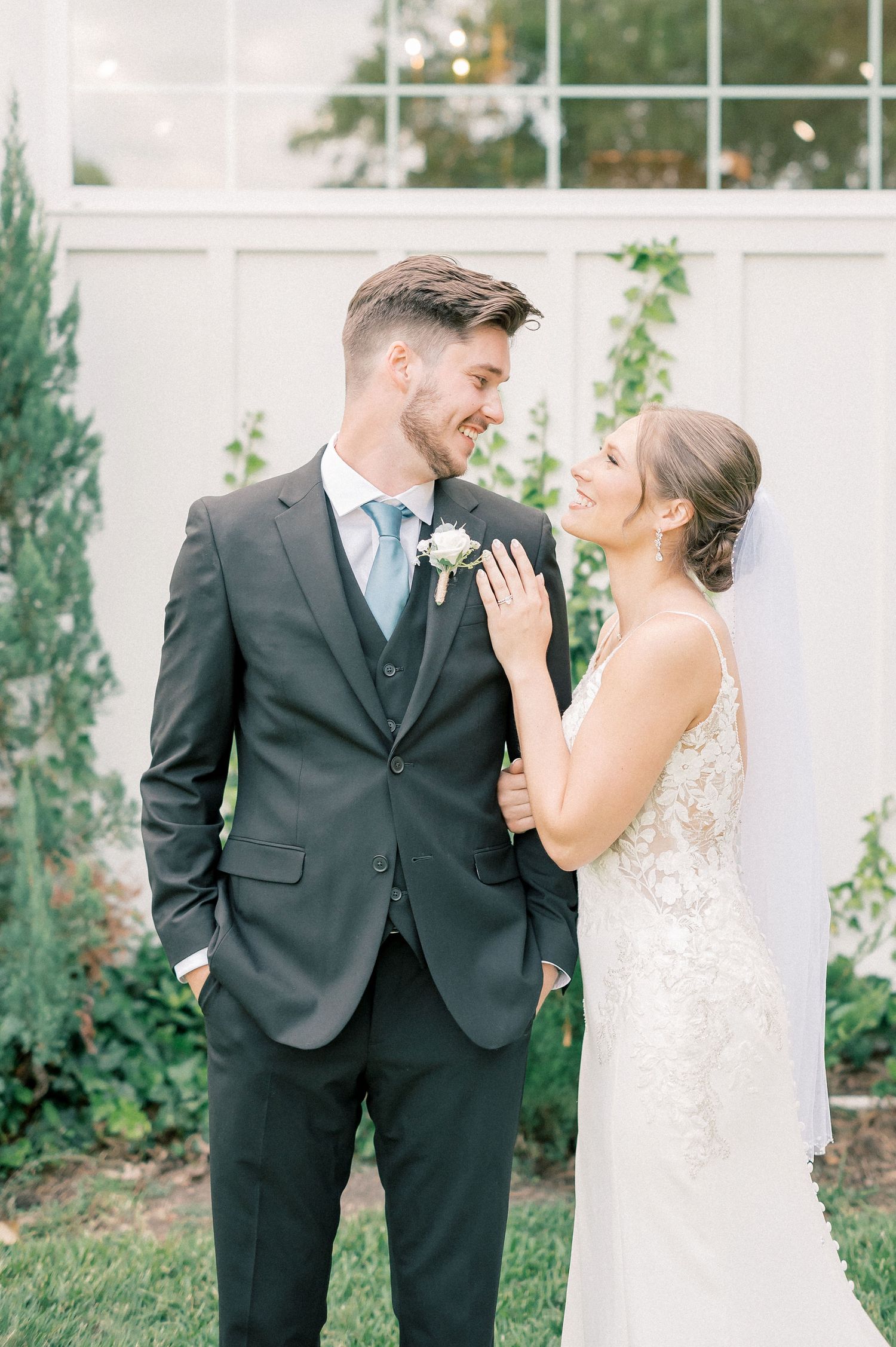 Wedding couple sharing emotional first look moment in garden setting.