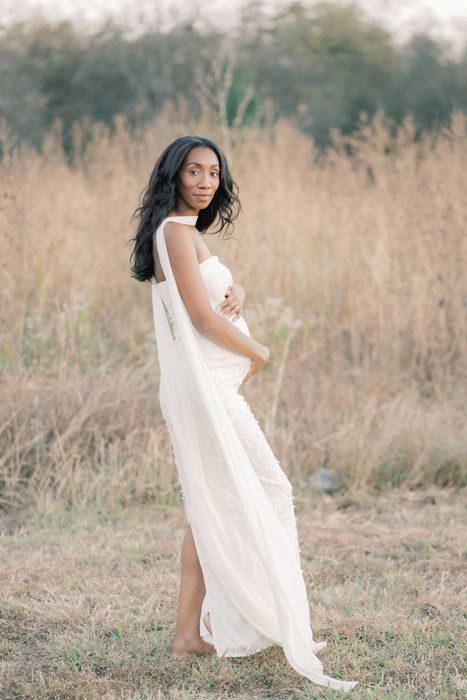 Elegant white dress flowing in a golden field during a dreamy outdoor photoshoot.