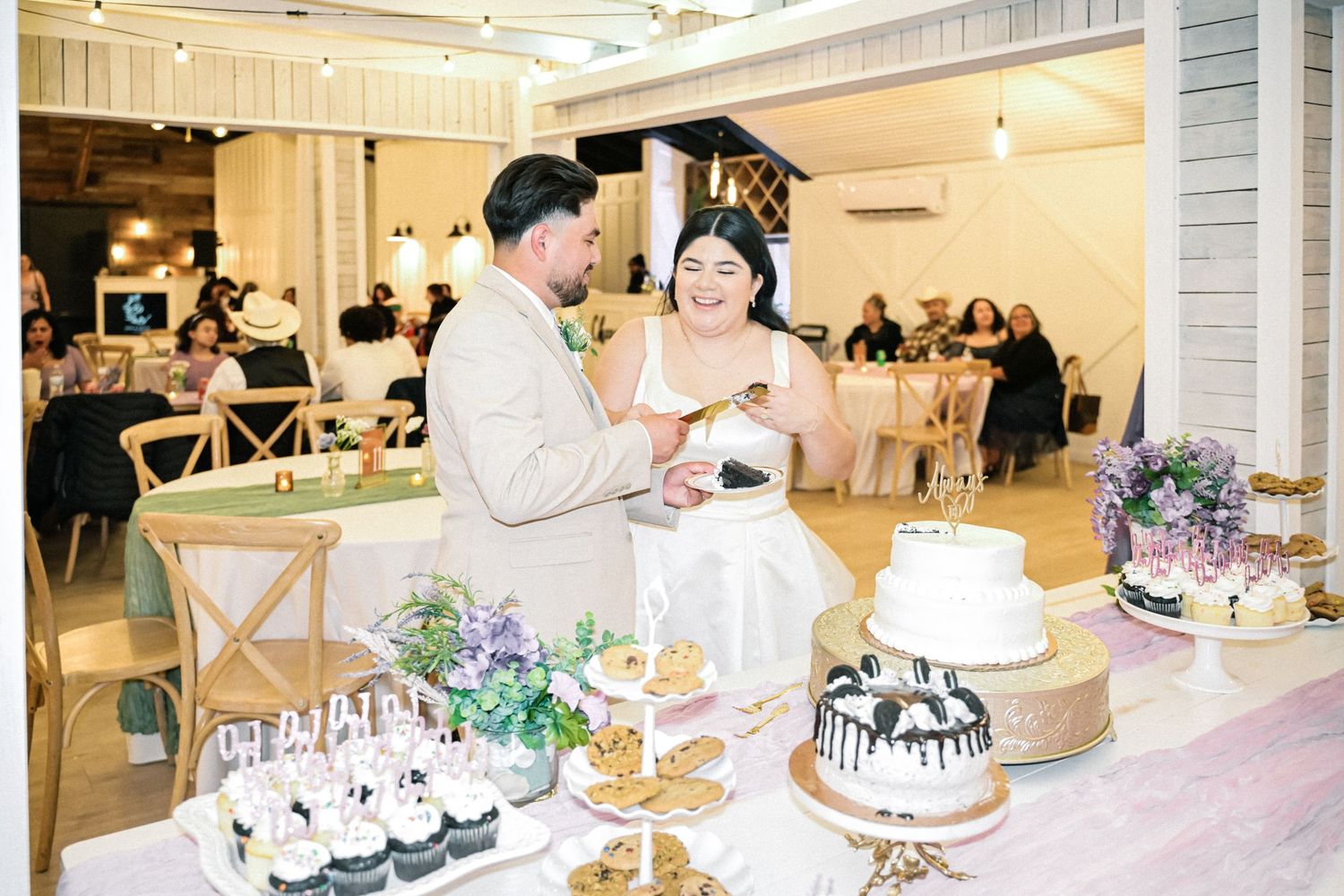 Newlyweds sharing a joyful moment while cutting cake at their wedding reception.