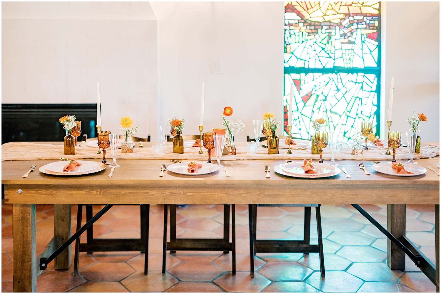 Elegant wedding reception table setting with rustic wooden tables and delicate floral centerpieces.