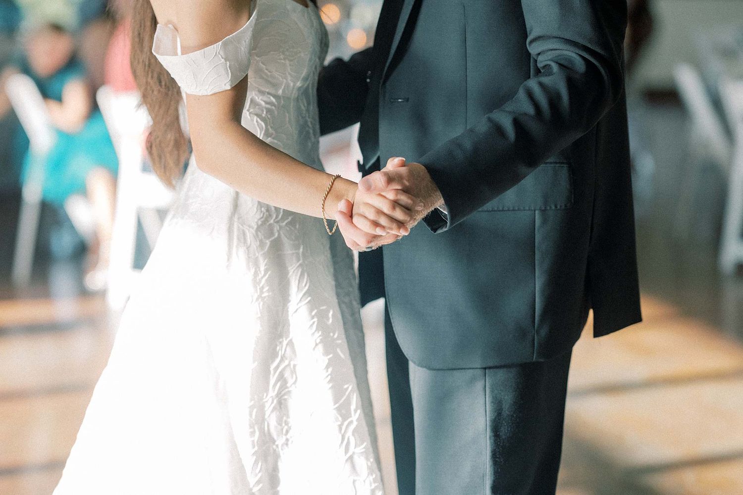 Formal wedding attire details showing white dress and dark suit during celebration.