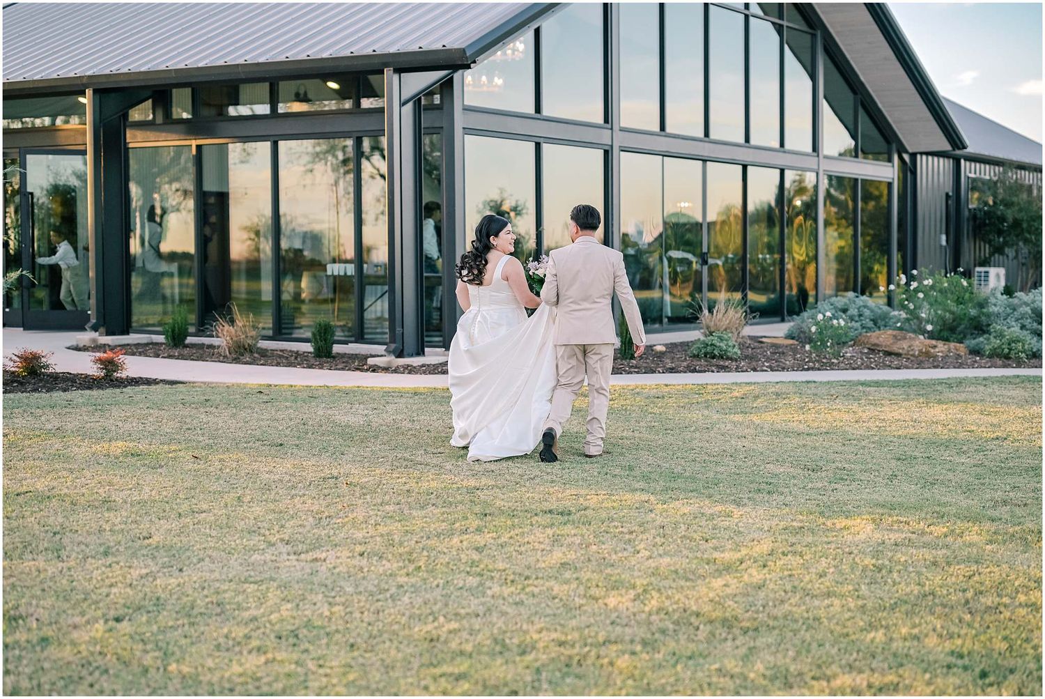 Modern glass and steel wedding venue with sleek architectural design in natural setting.