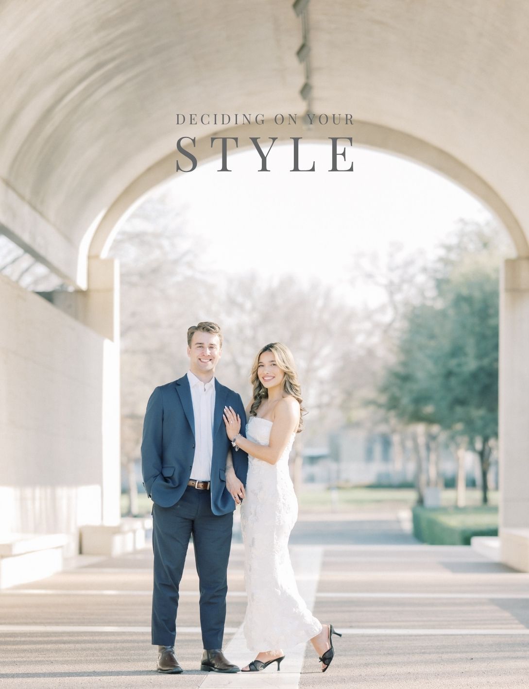 Stylish engaged couple posing under arched colonnade for engagement session style inspiration guide.