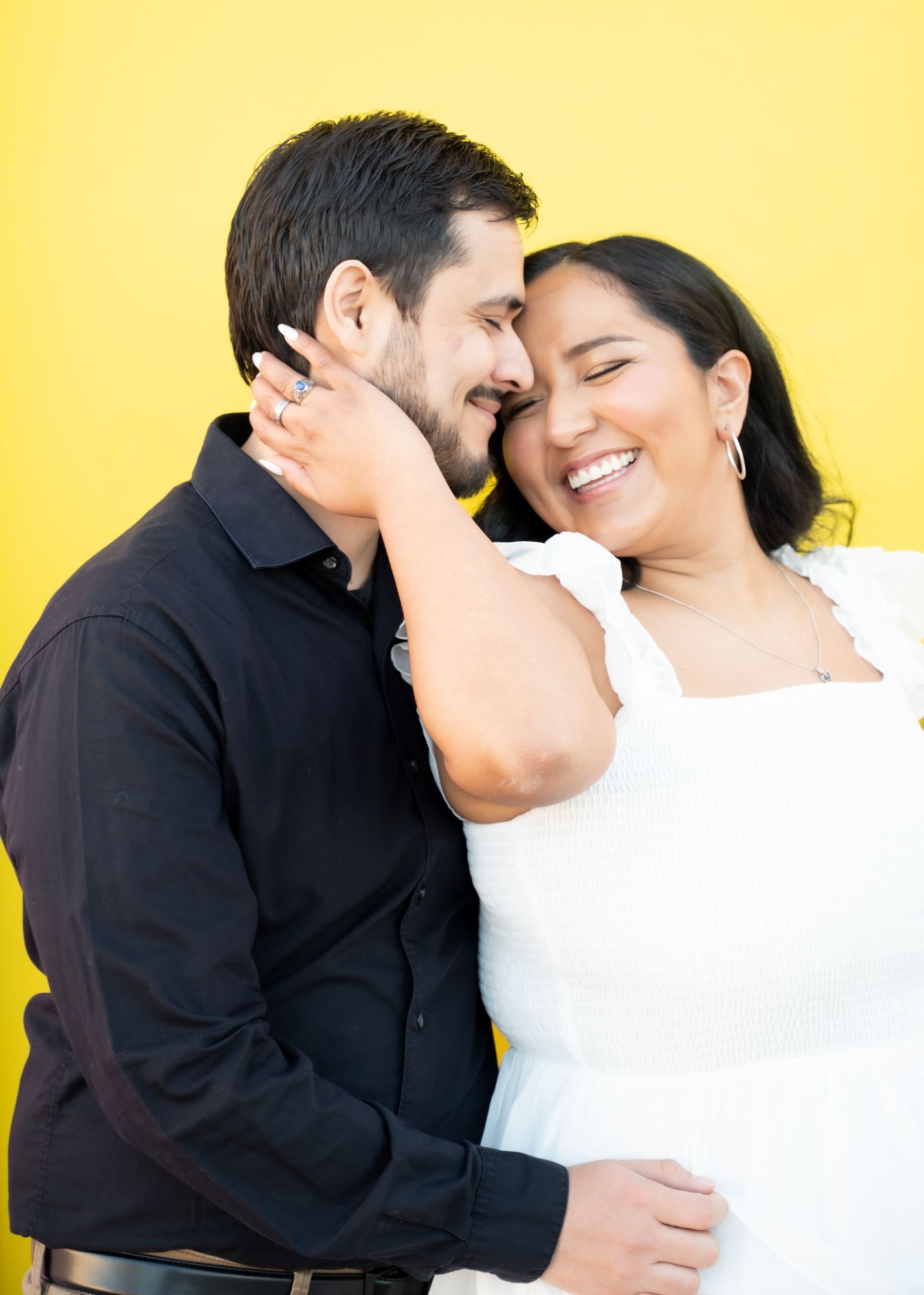 A romantic couple sharing an intimate moment against a bright yellow background.